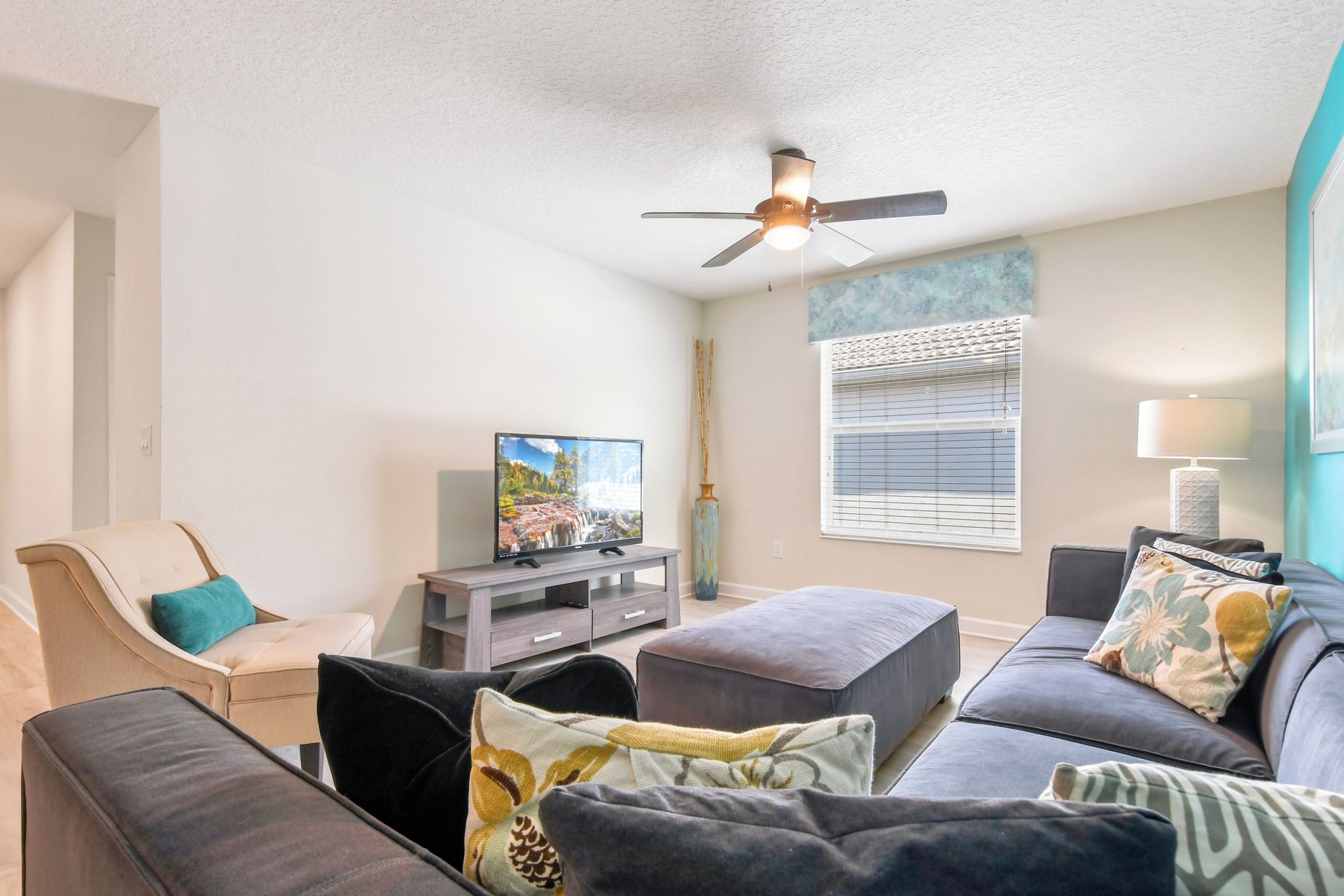Cozy living room with plush seating, smart TV, and vibrant accent wall.