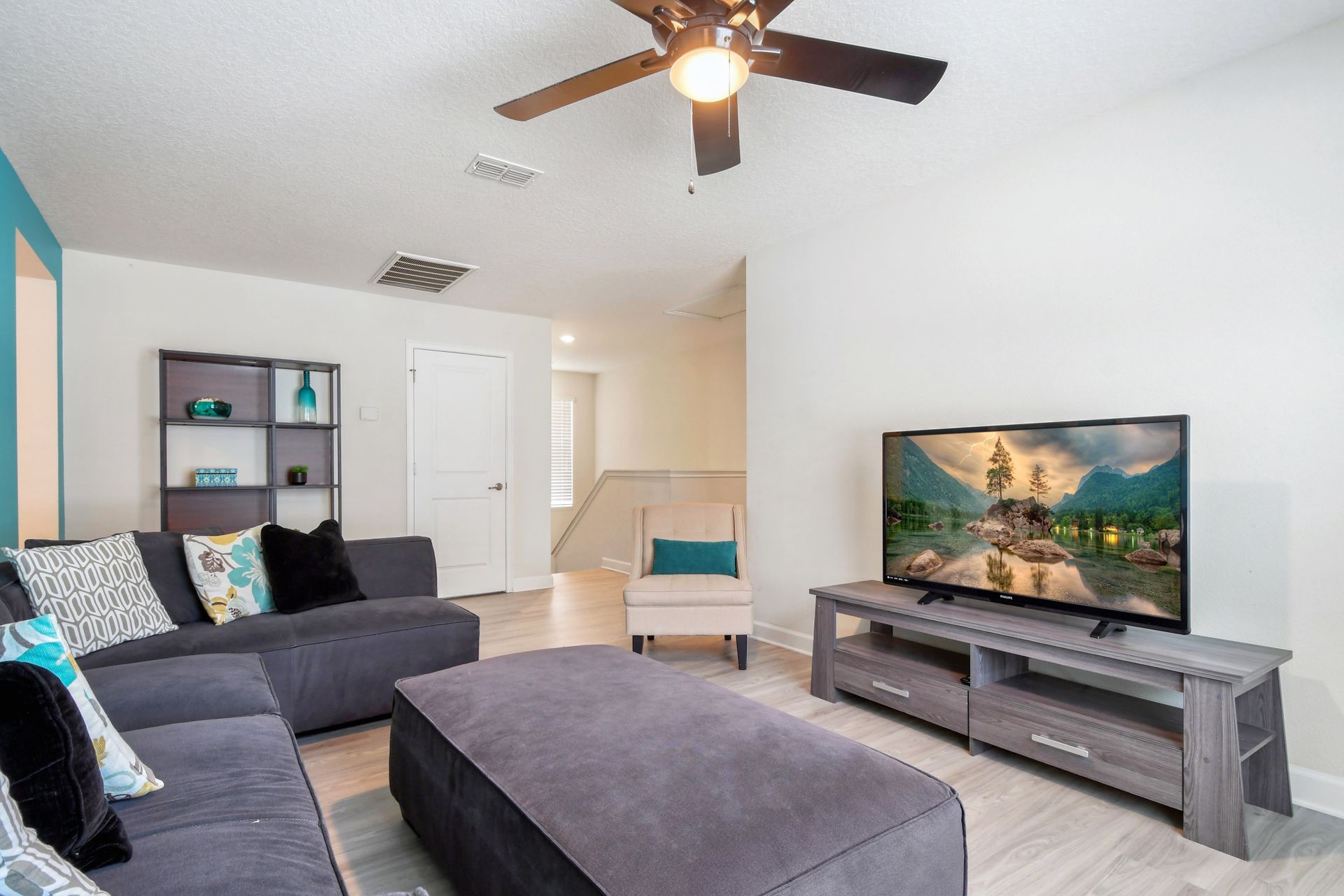 Upstairs loft with comfy sectional, large smart TV, and relaxing modern style.