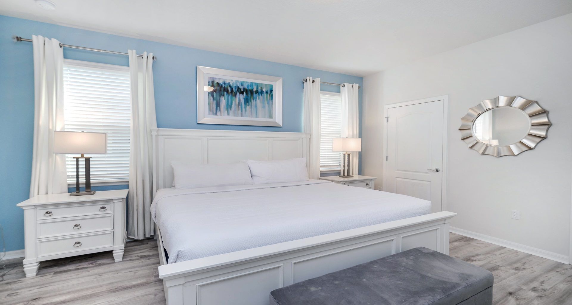 Bright and airy king bedroom with soft blue accents and elegant modern touches.