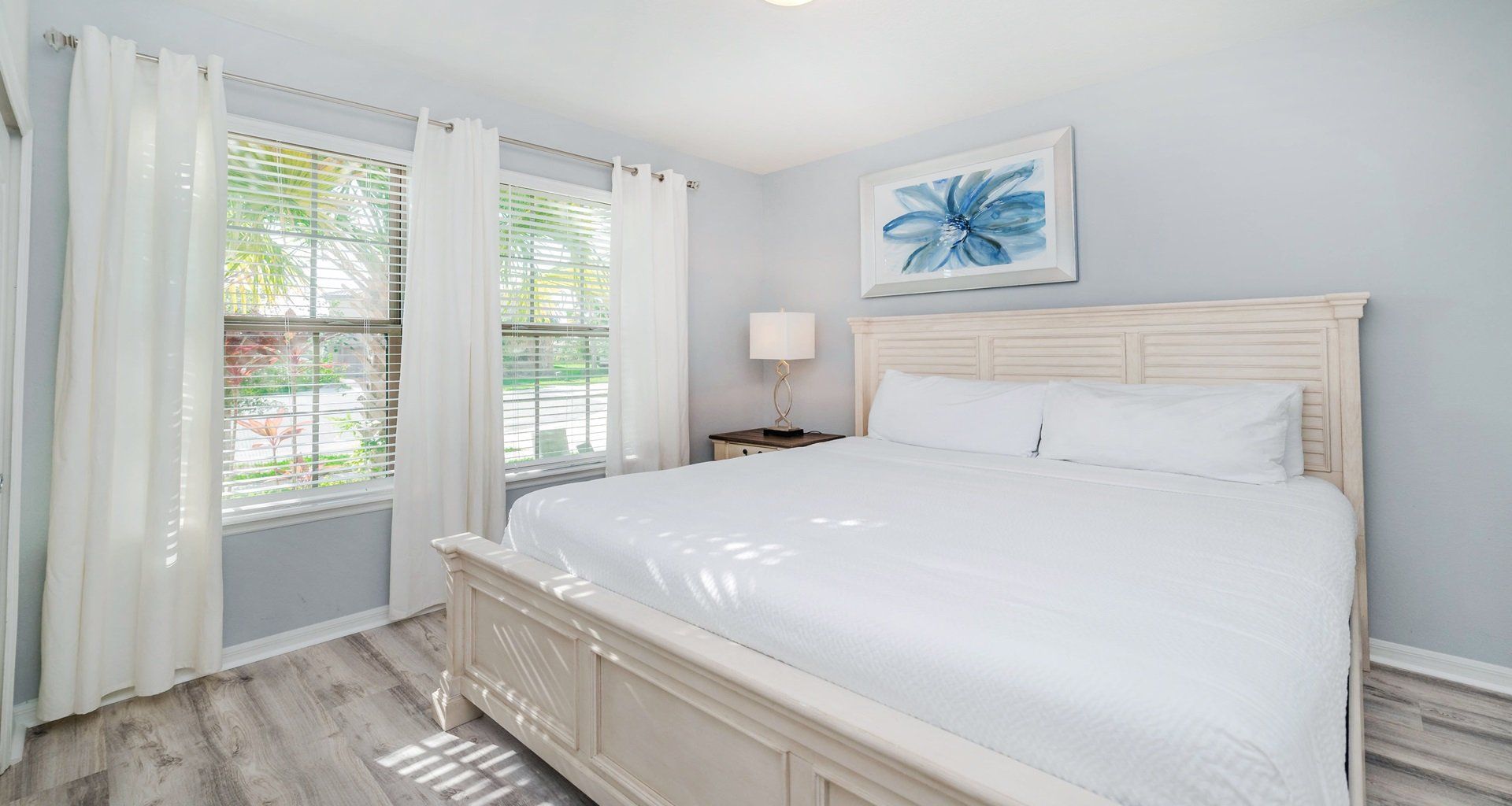 Sunny bedroom with king bed, peaceful views, and soft coastal-inspired decor.