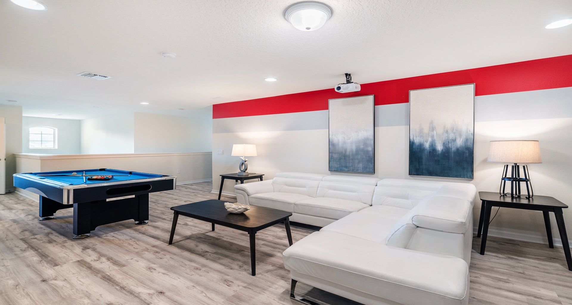 Upstairs lounge with pool table, cozy sectional, and projector for movie nights.