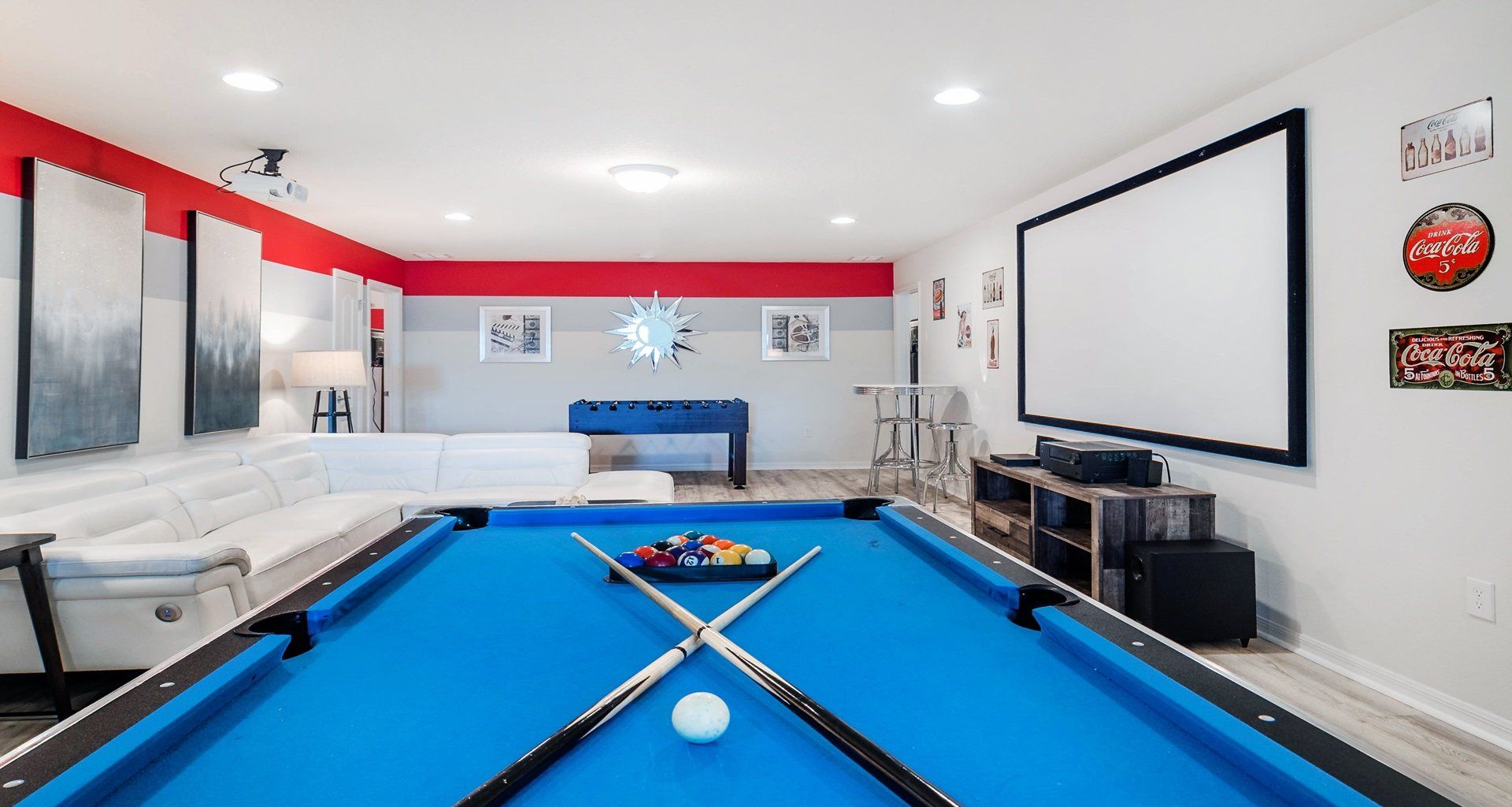Ultimate game room with pool table, foosball, theater screen, and retro vibes.