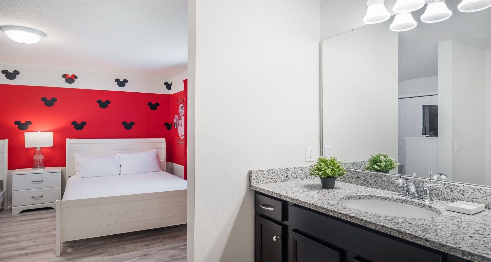 Granite vanity bathroom with direct access to a cheerful Mickey-themed bedroom.