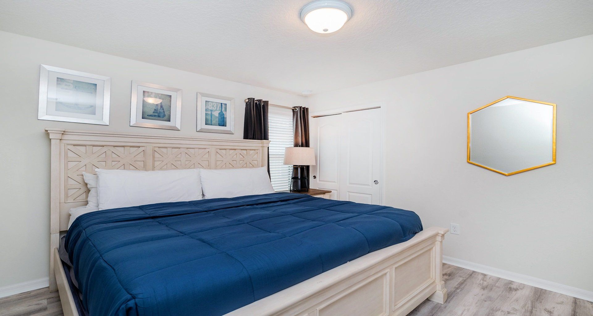 Cozy bedroom with king bed, soft lighting, and calming modern coastal decor.