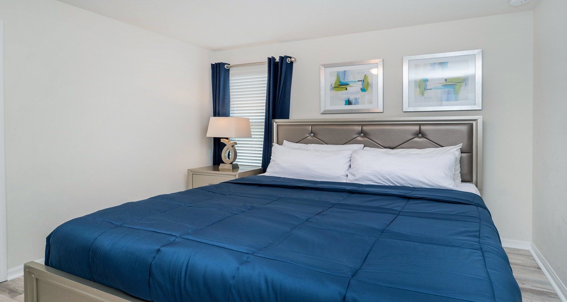 Chic king bedroom with rich blue accents and a sleek, contemporary design.