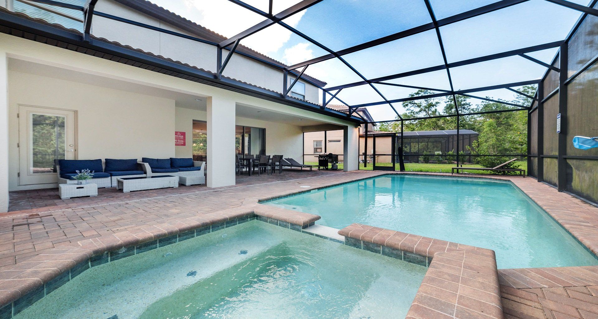 Screened pool and spa with lounge seating, outdoor dining, and private backyard.