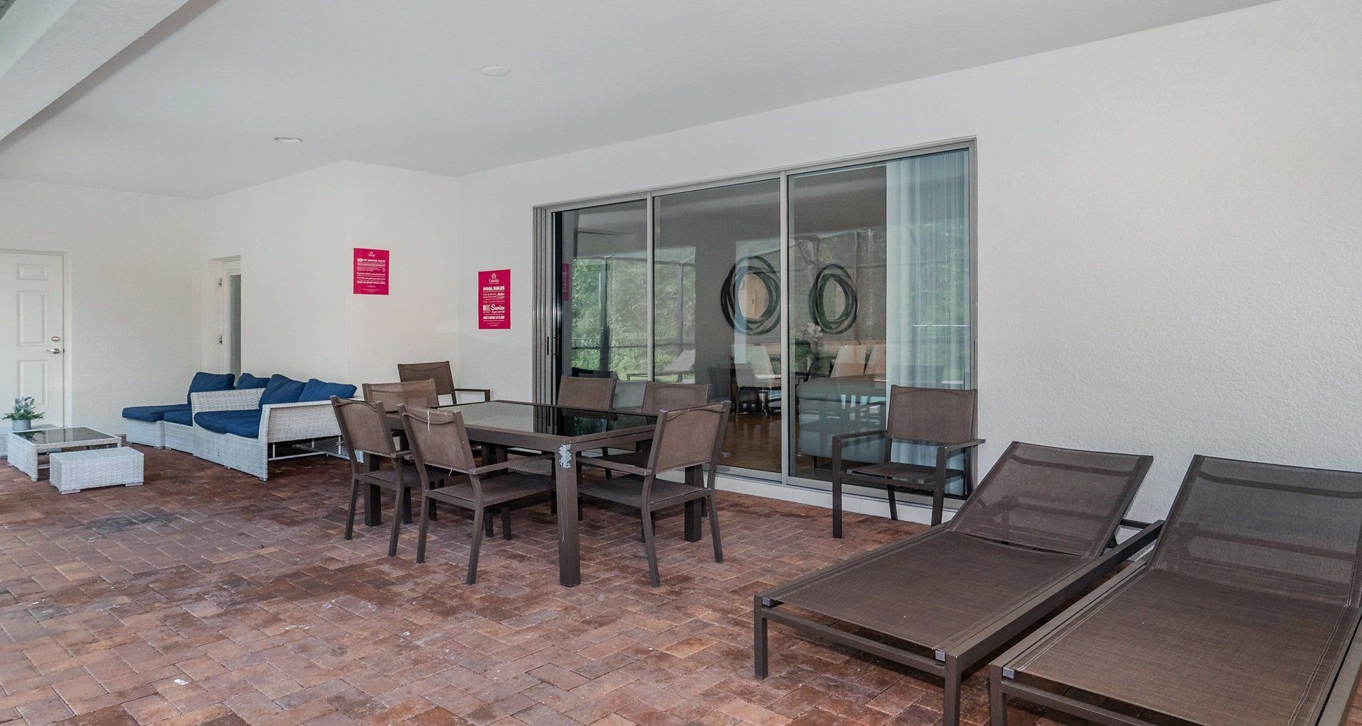 Covered patio with dining table, lounge chairs, and cozy outdoor seating area.