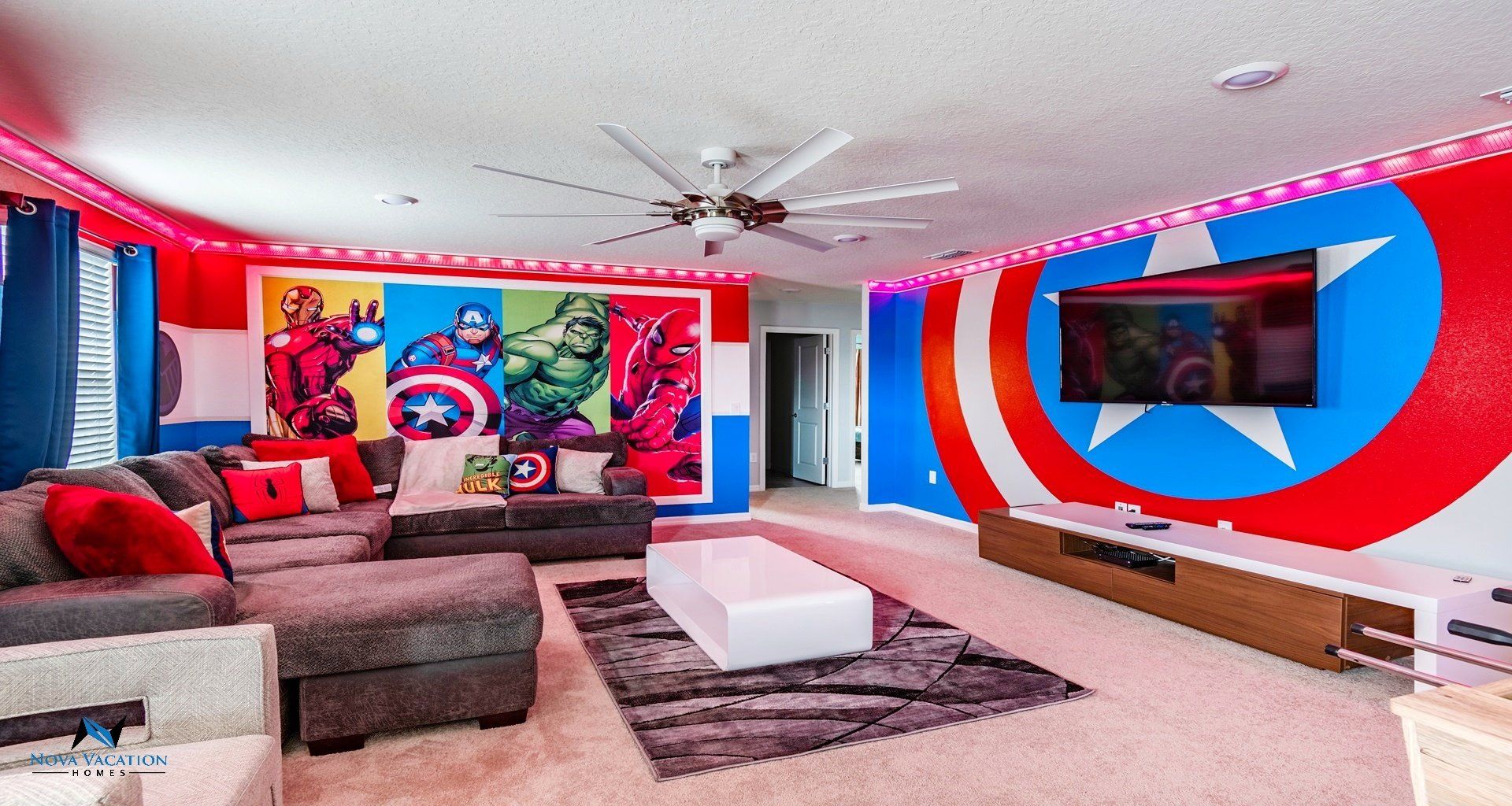 Avengers themed loft room with a large couch and a huge flat screen TV.