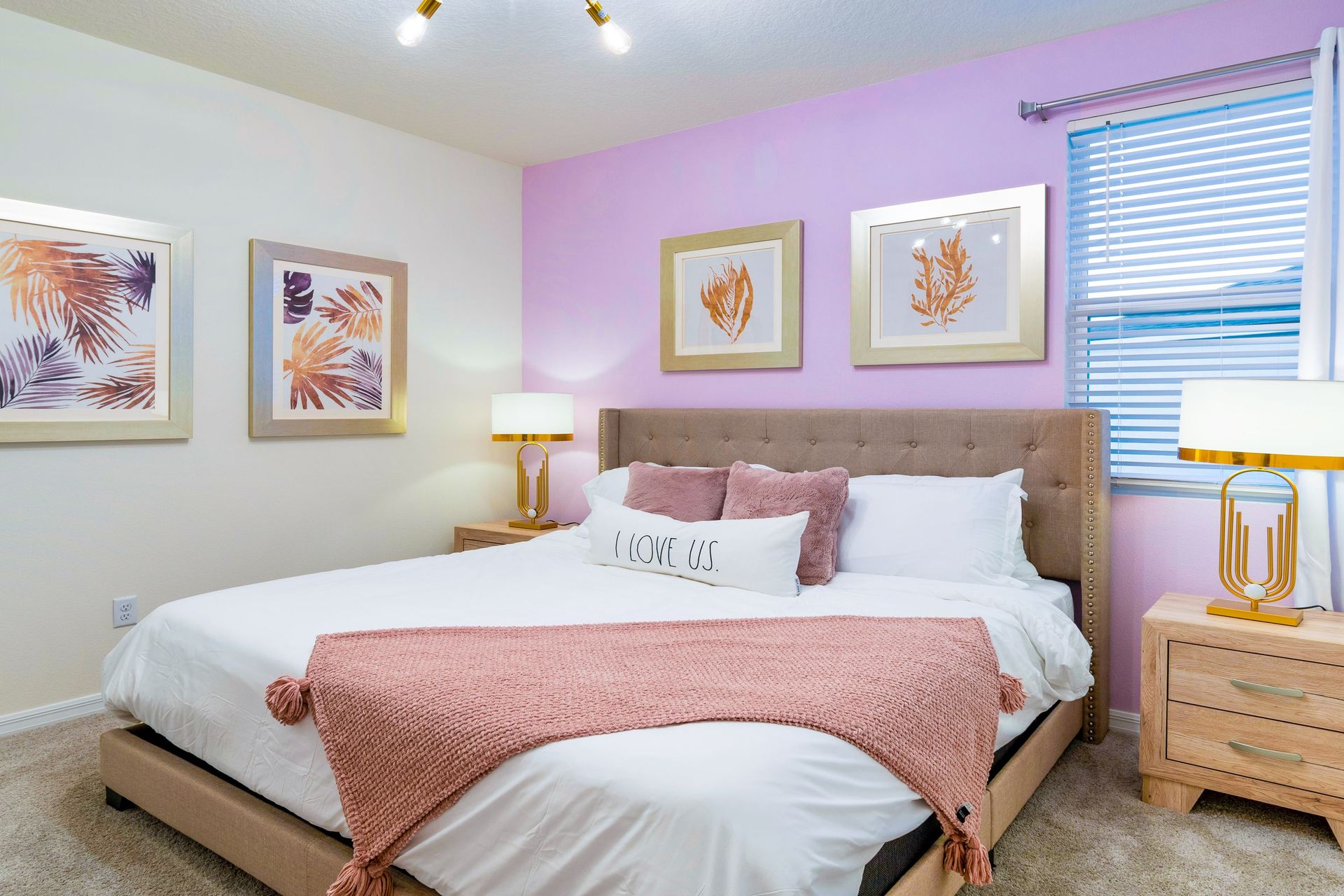 Stylish bedroom with soft pastel accents, cozy bedding, and TV!