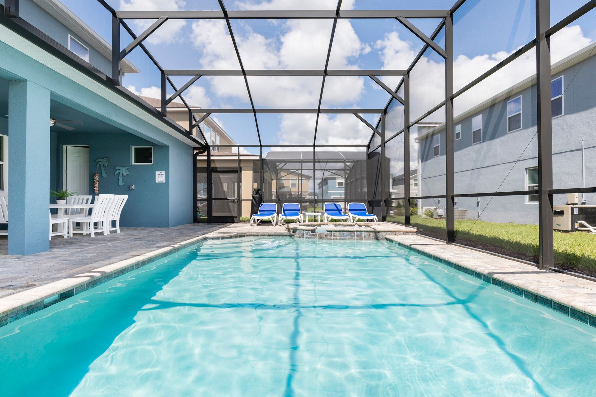 Screened private pool with lounge chairs, patio dining, and sunny vibes!