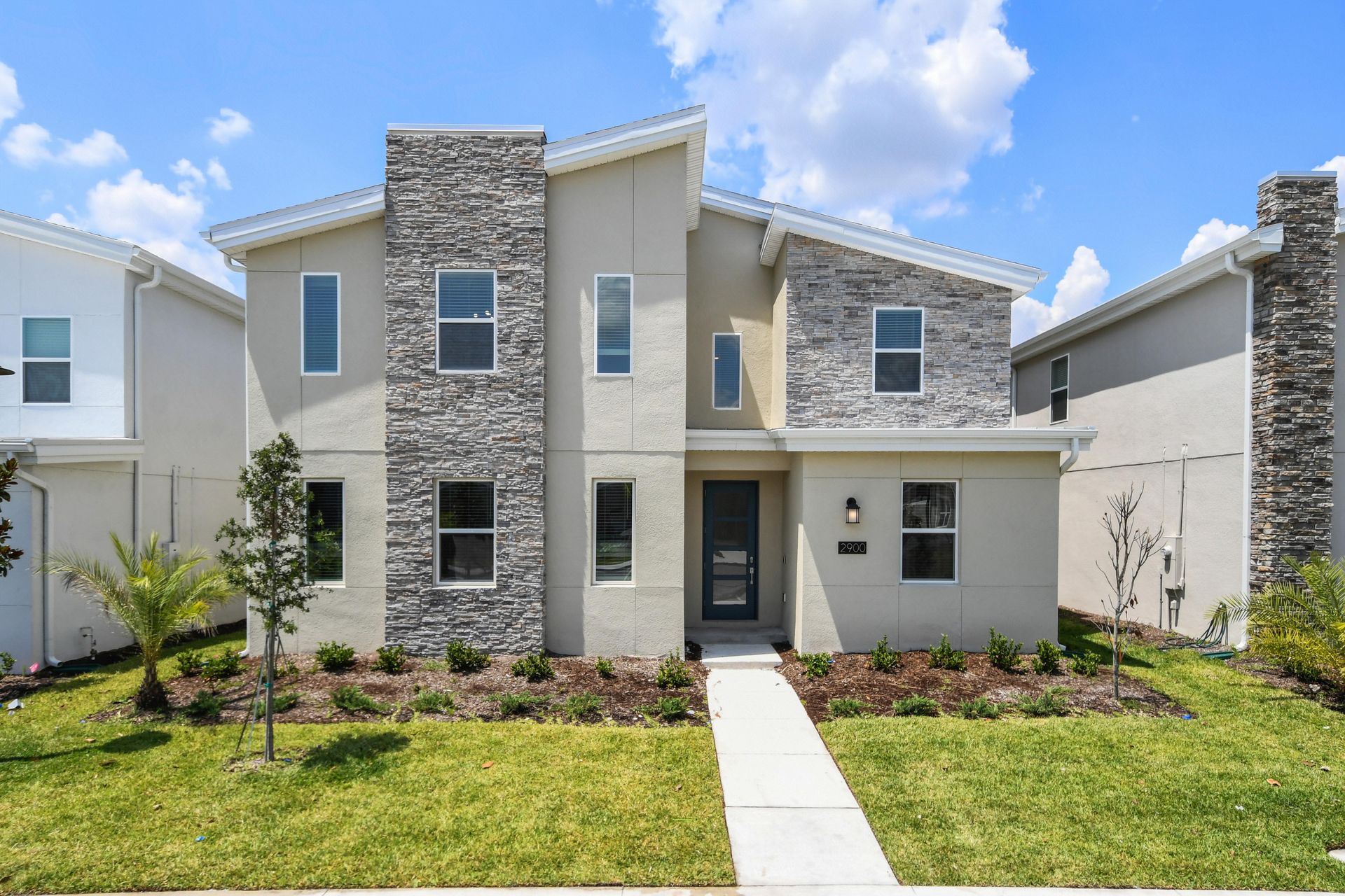 Modern luxury home with sleek stone accents, bright interiors, and stylish design.
