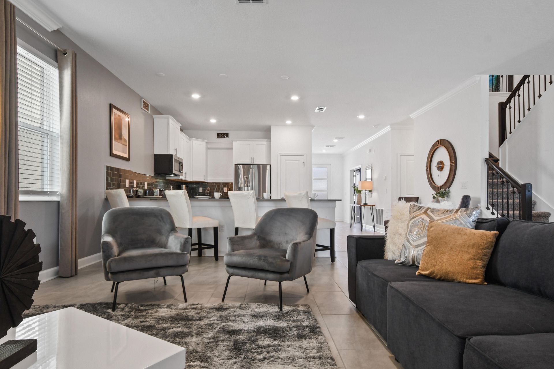 Stylish open-concept living space with modern decor, cozy seating, and a sleek kitchen.