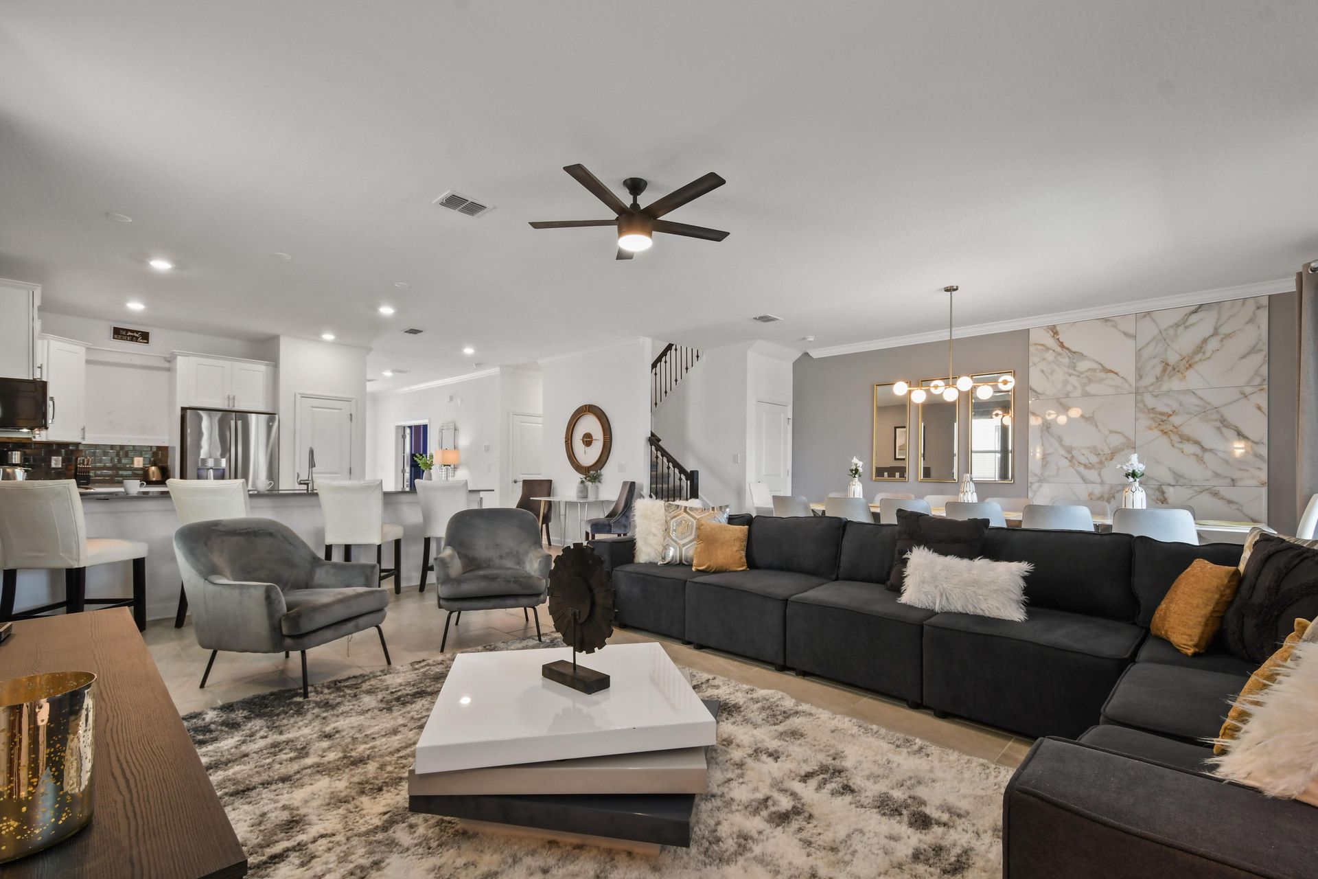 Stylish open-concept living space with modern decor, cozy seating, and a sleek kitchen.