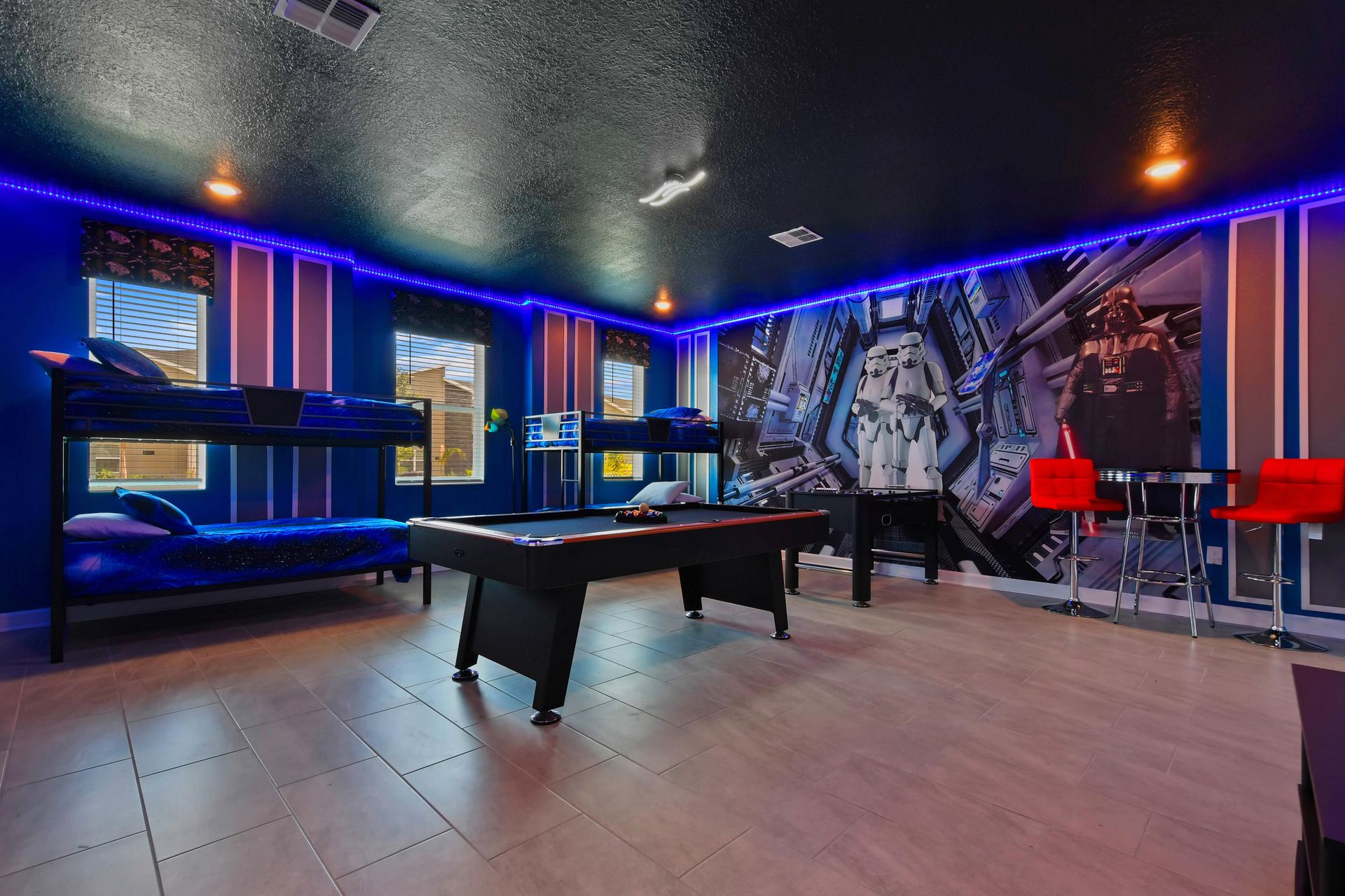 Galaxy-themed game room with bunk beds, pool table, and glowing LED lighting.