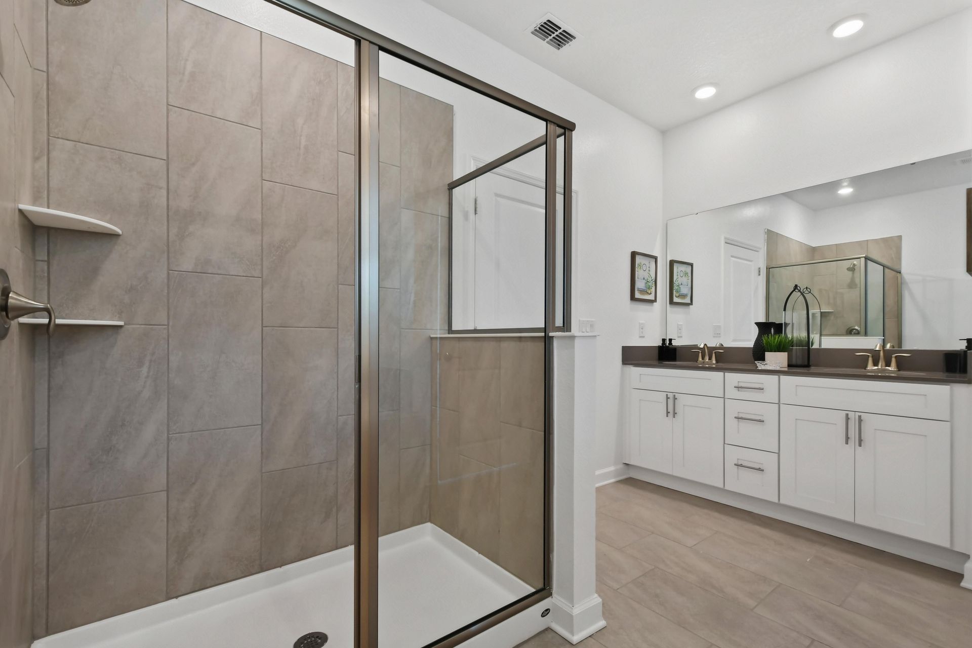 Modern bathroom with a spacious glass shower, dual-sink vanity, and sleek finishes.