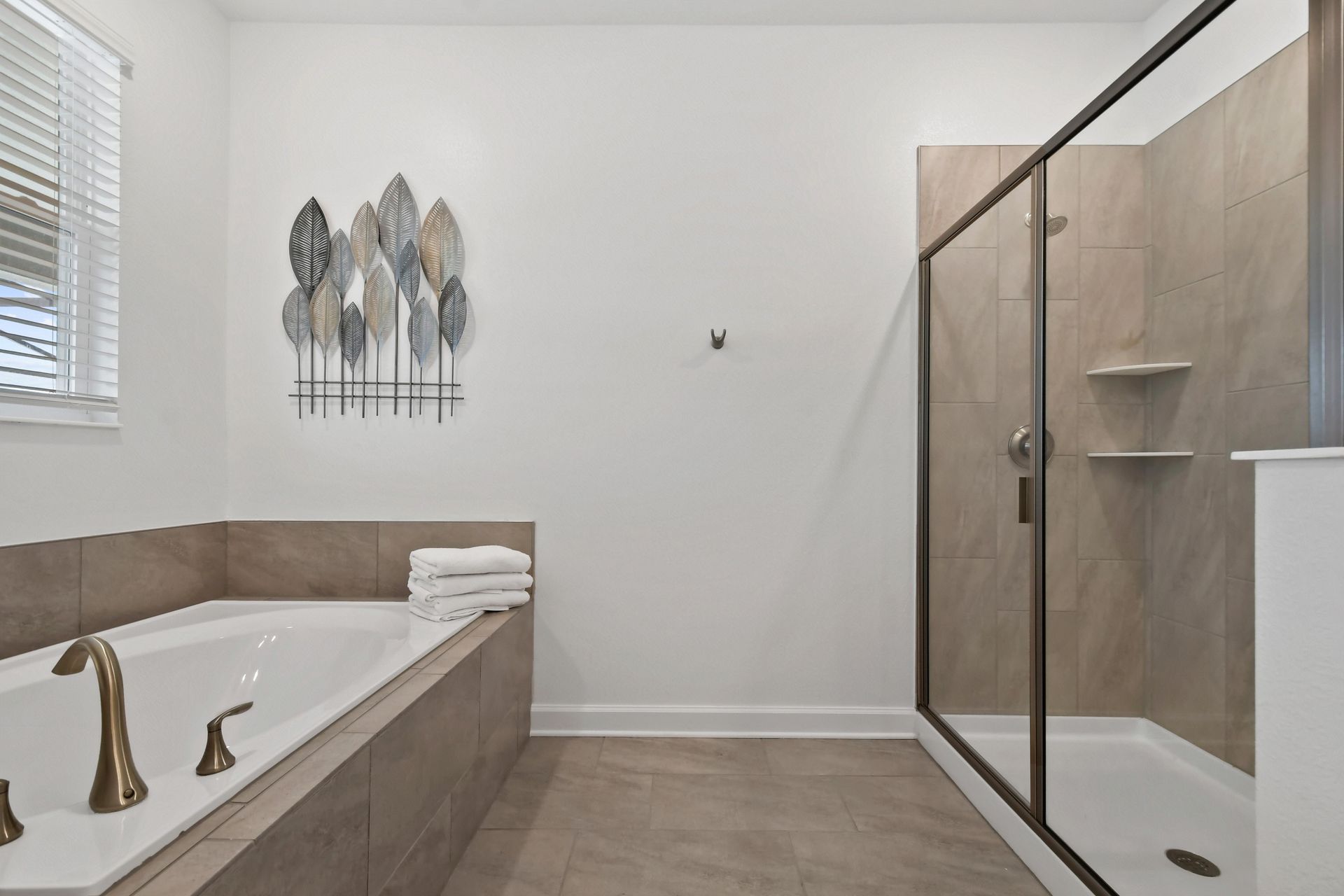 Luxury bathroom with a soaking tub, glass-enclosed shower, and elegant modern design.