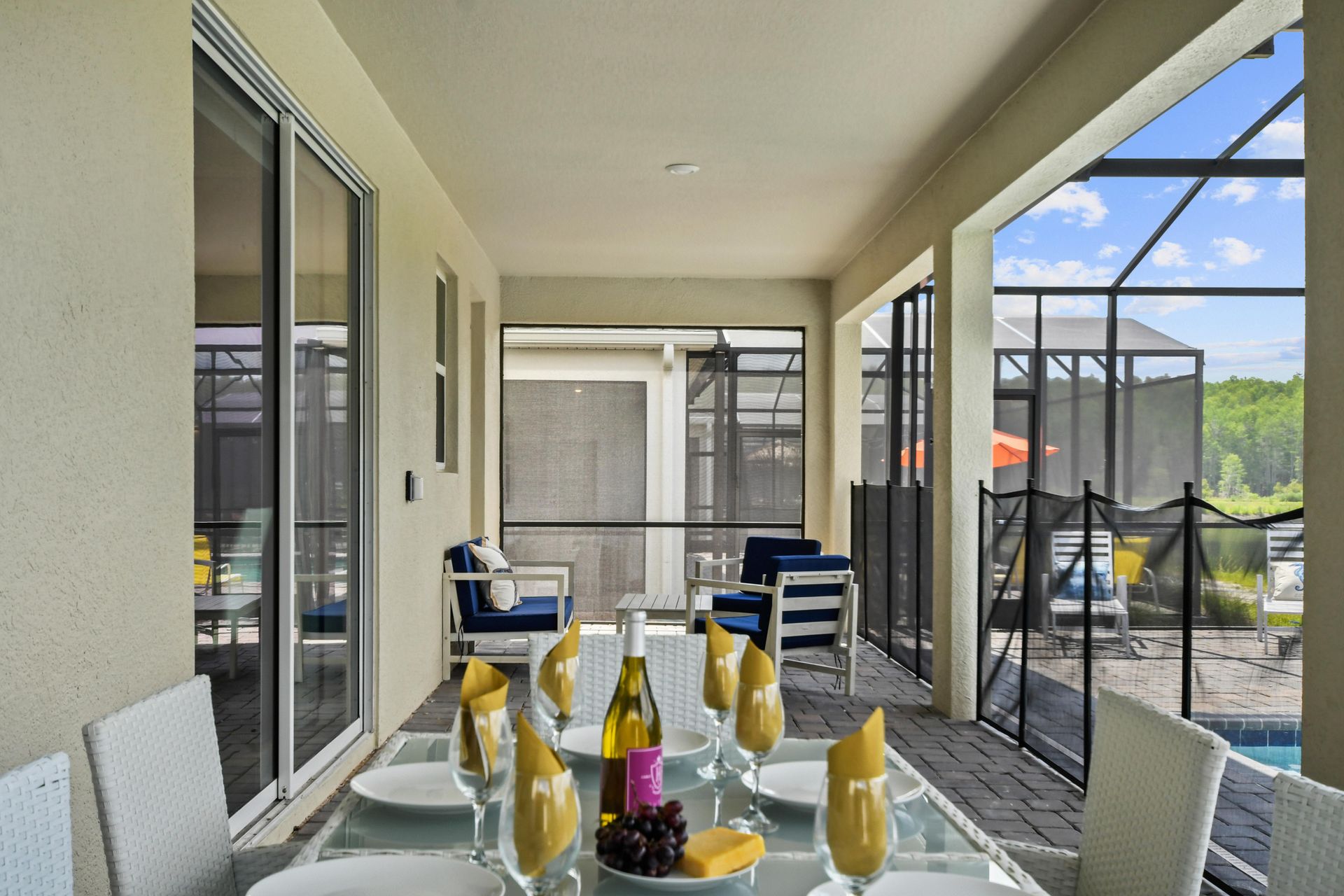 Elegant screened-in outdoor dining area with modern white seating for a relaxing meal.