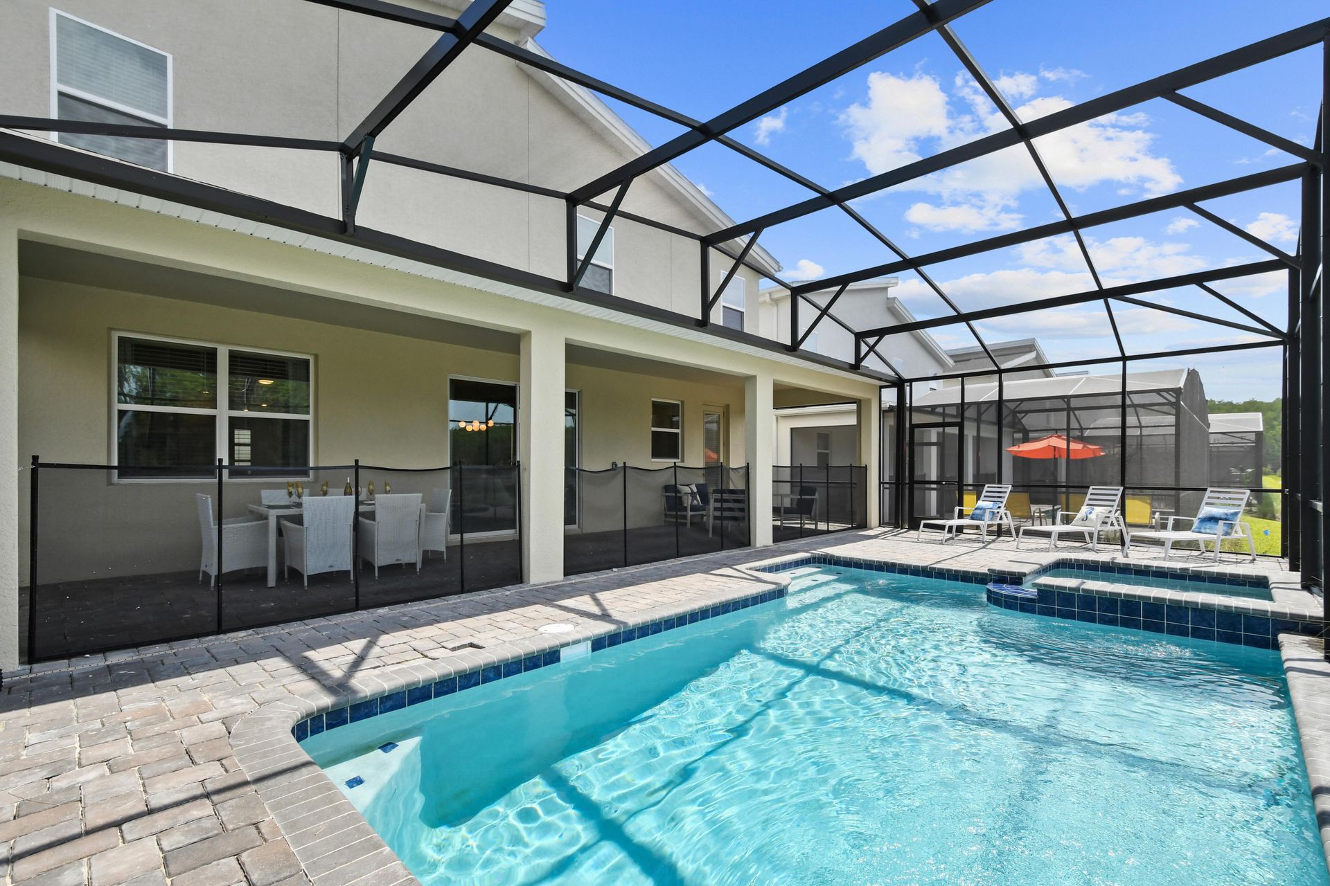 Screened-in pool and spa with lake views, lounge chairs, and a relaxing outdoor vibe.