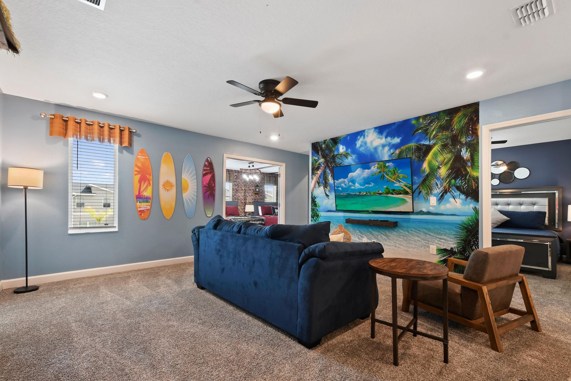Tropical-themed lounge with vibrant decor, cozy seating, and a stunning beach mural.