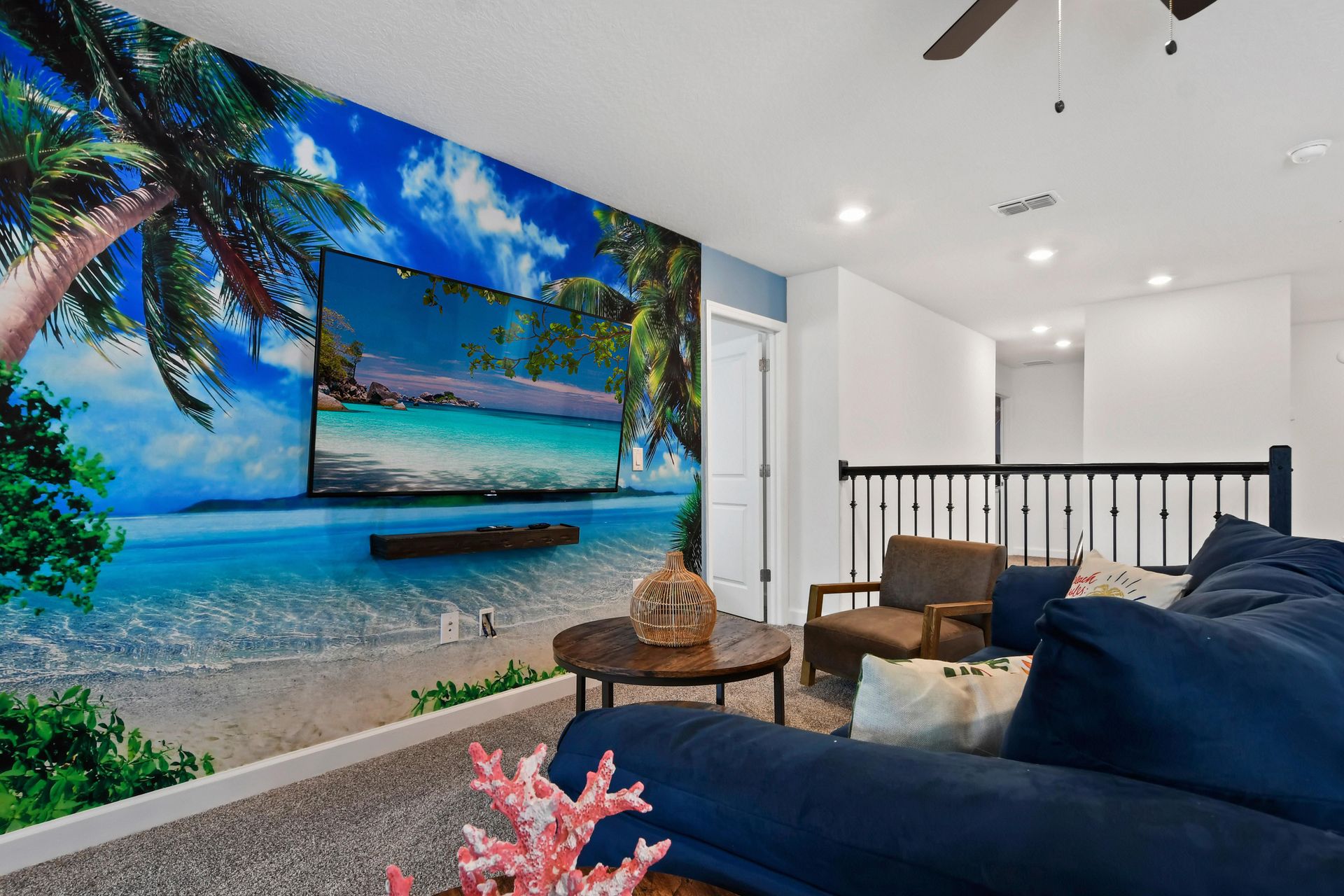 Tropical-themed lounge with vibrant decor, cozy seating, and a stunning beach mural.