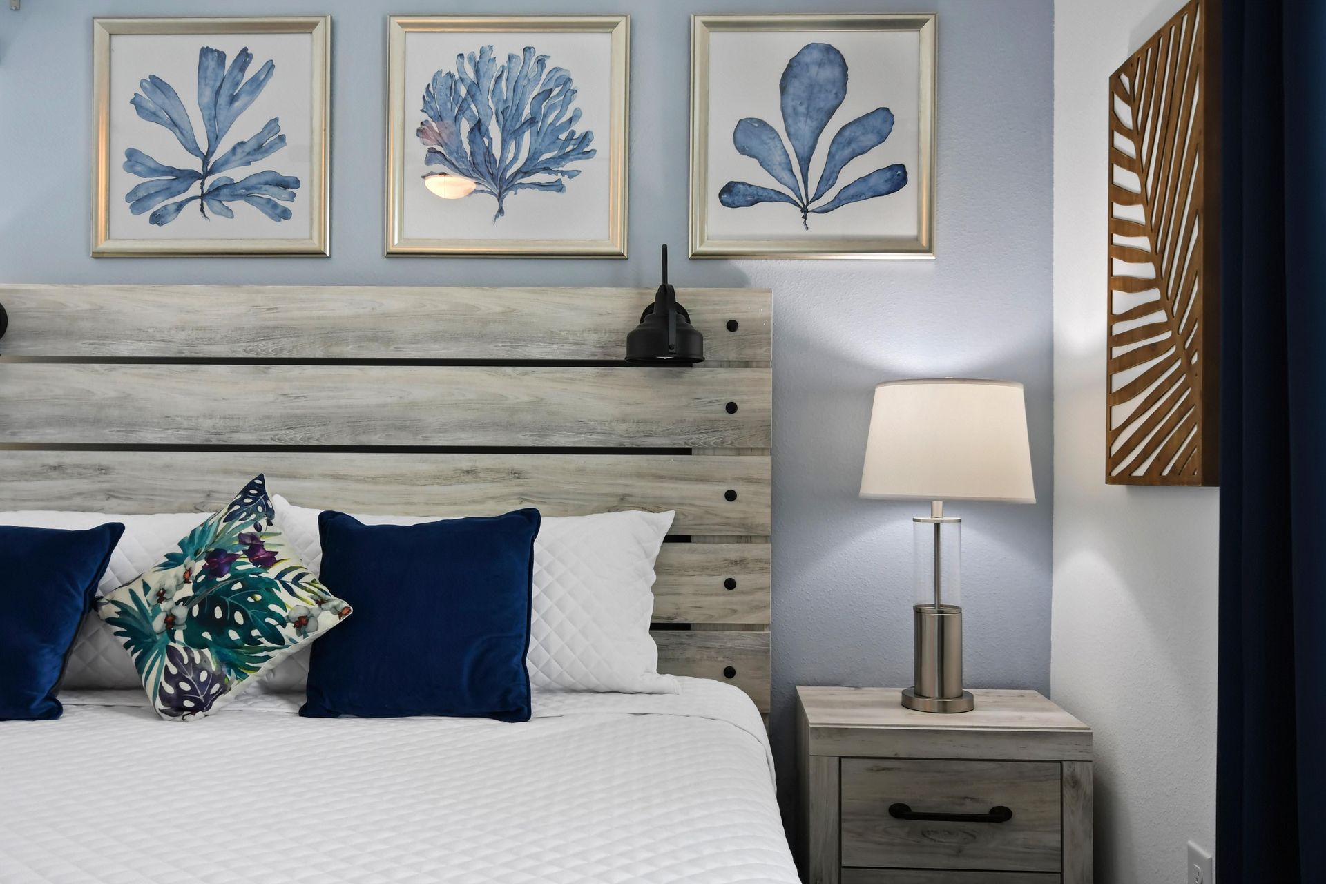 Coastal-inspired bedroom with a king bed, rustic wood accents, and serene decor.