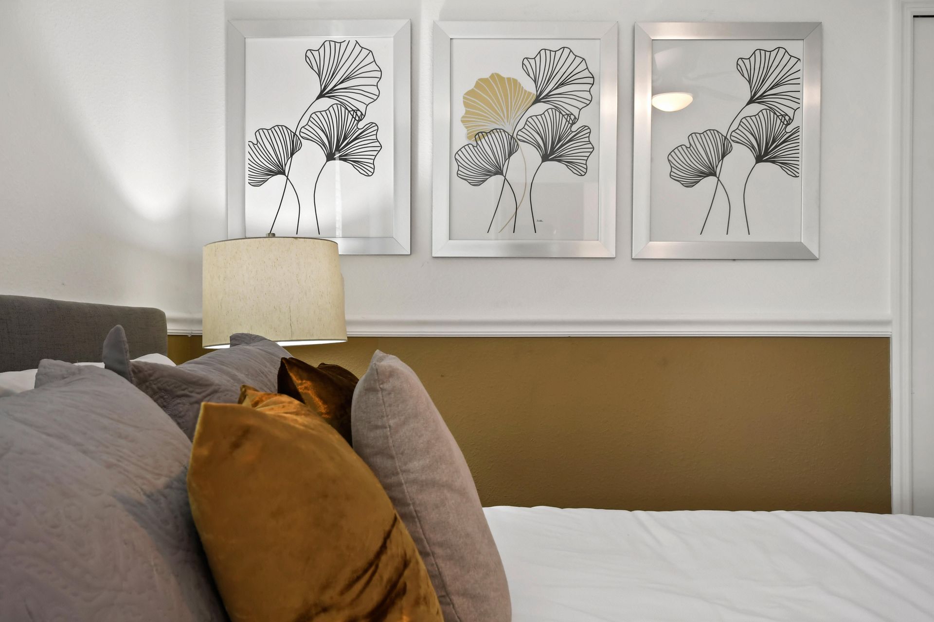 Elegant bedroom with a king bed, gold accents, and a cozy, stylish ambiance.