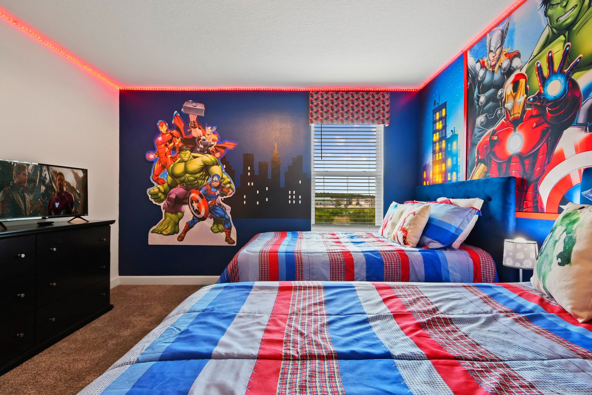 Action-packed superhero-themed bedroom with twin beds, bold decor, and vibrant lighting.