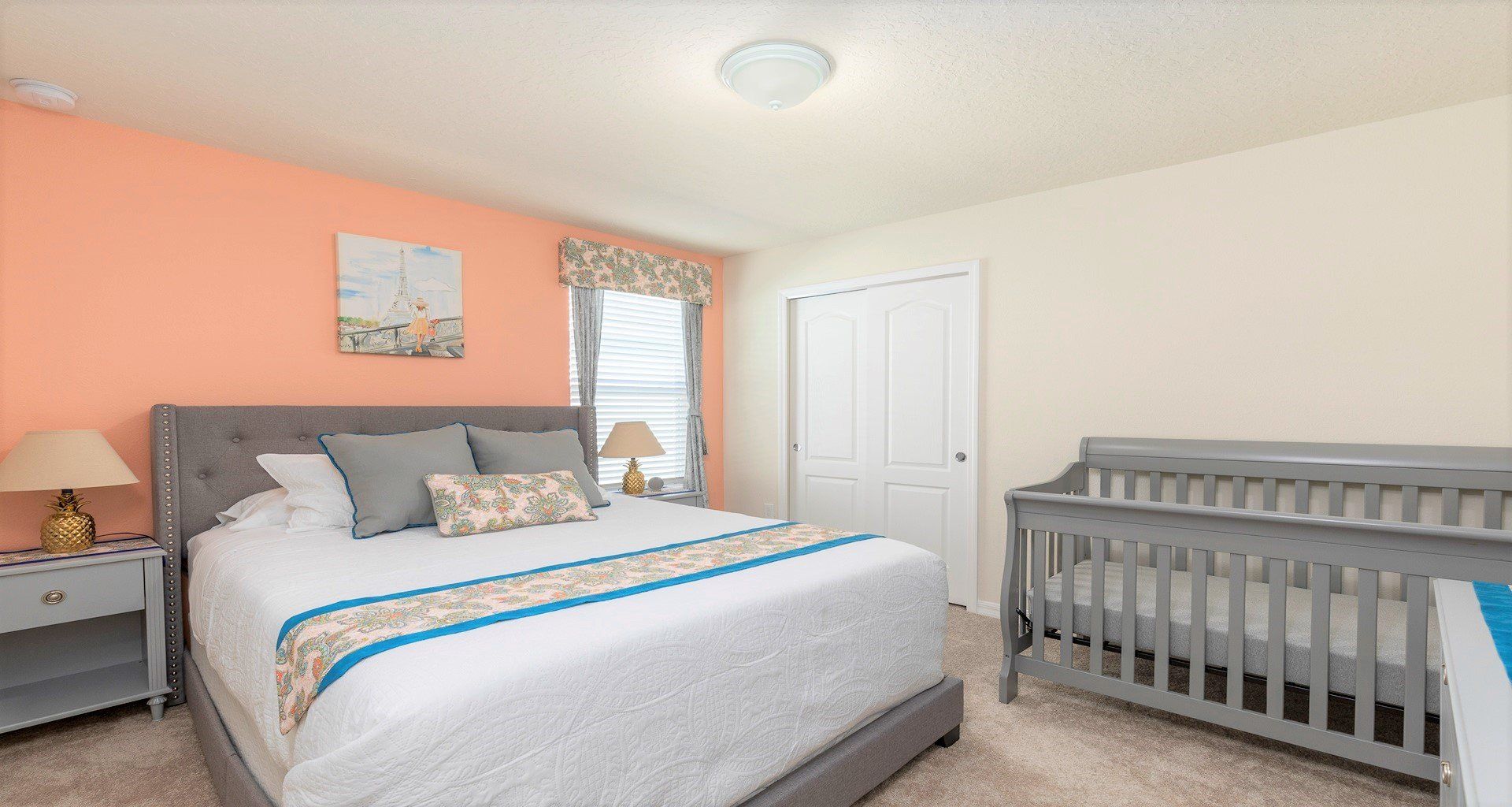 Cozy haven for parents & baby: crib, comfy bed & natural light.