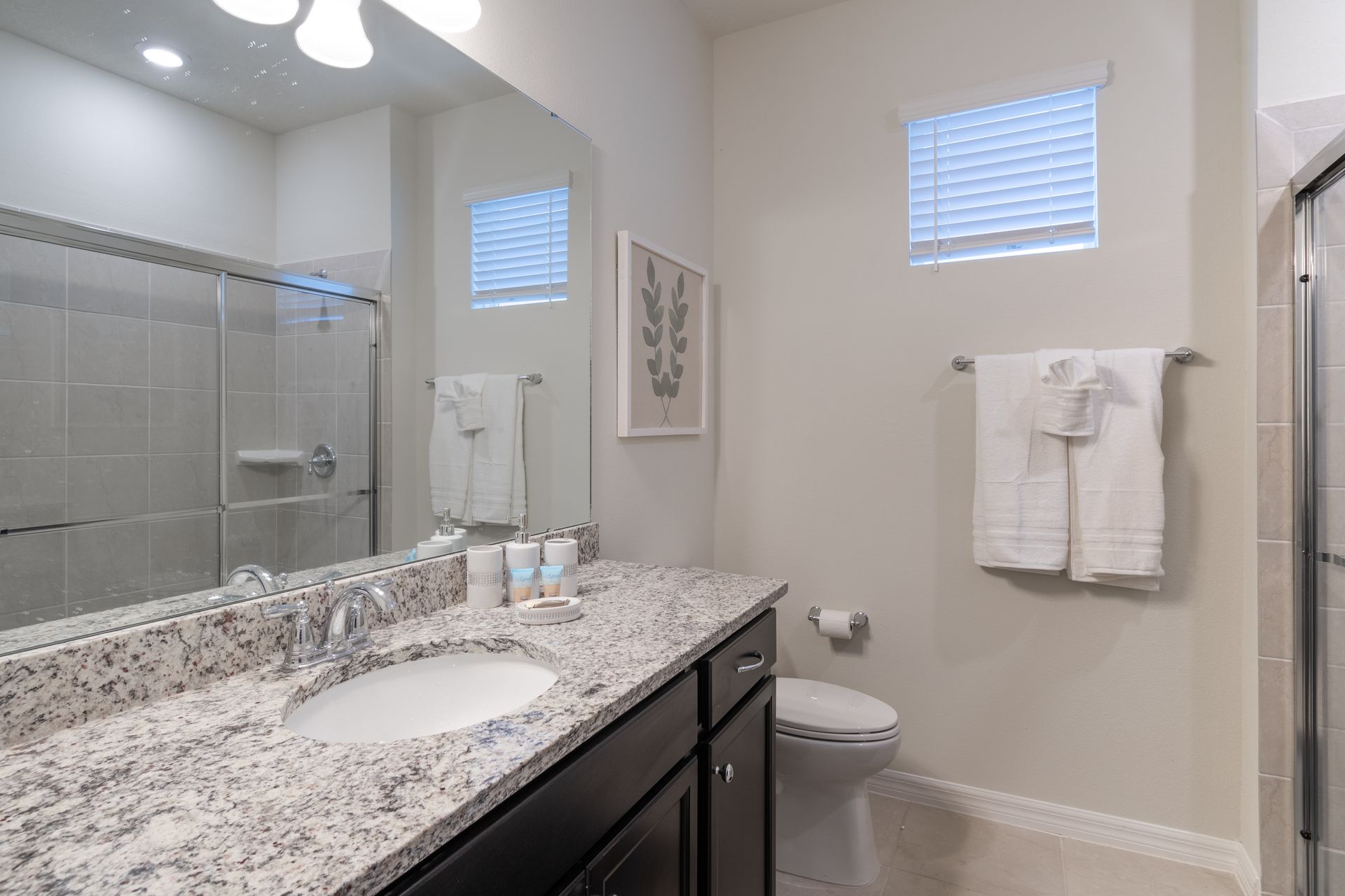 Charming modern bathroom with granite countertops, soft lighting & elegant décor!