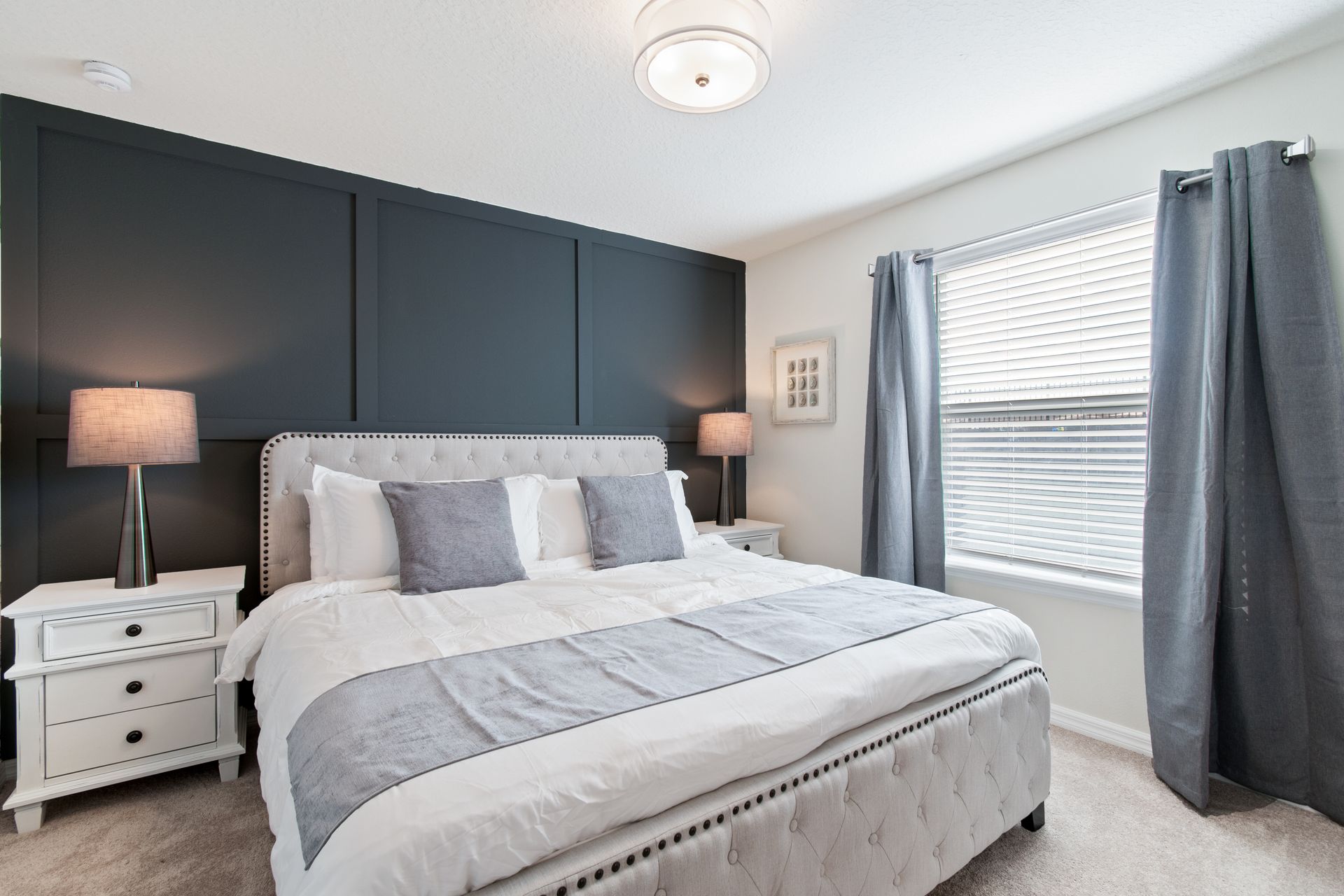 Stylish and cozy bedroom with a bold accent wall, plush bedding & soft lighting!