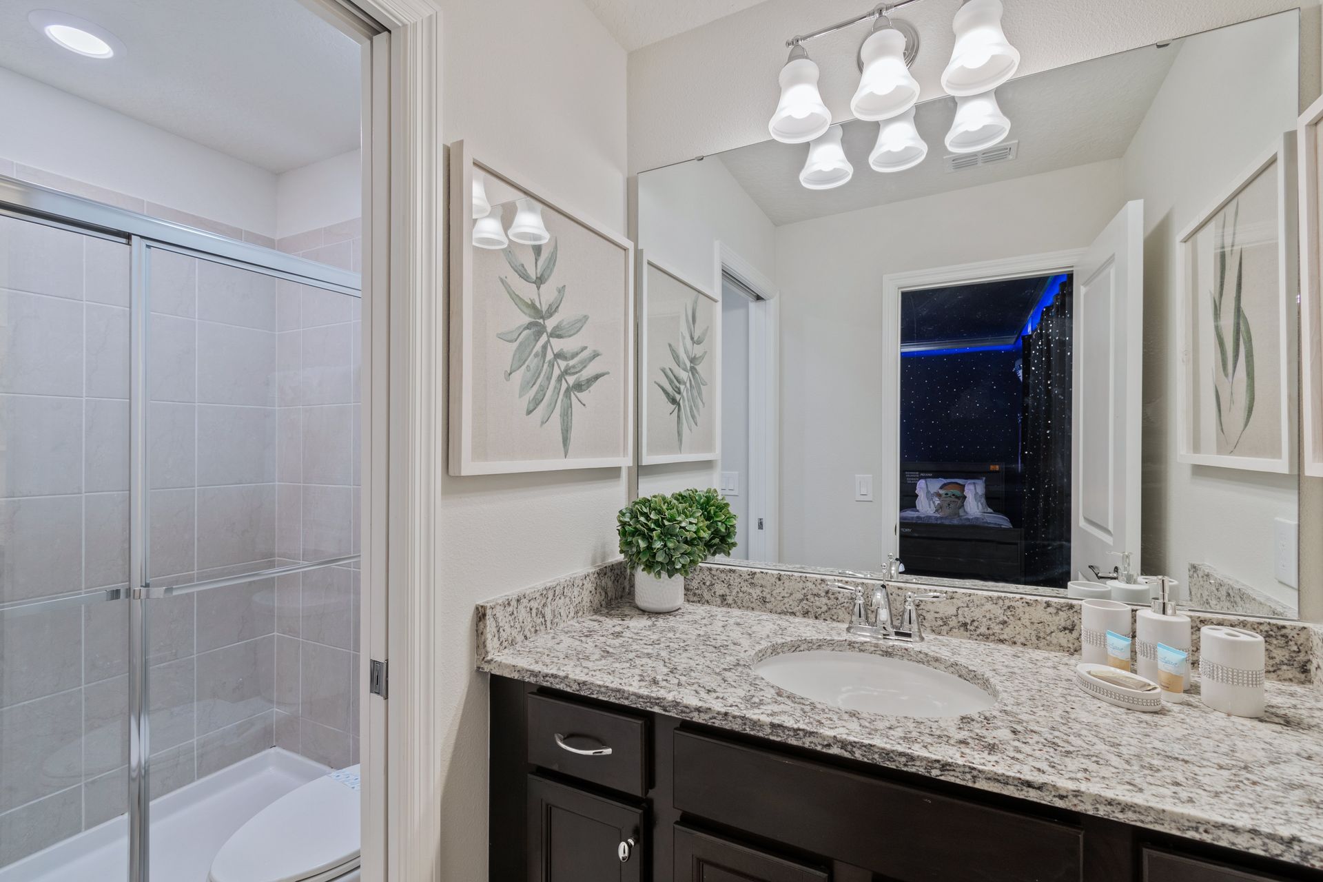 Modern bathroom with granite countertops, a glass walk-in shower & elegant touches!