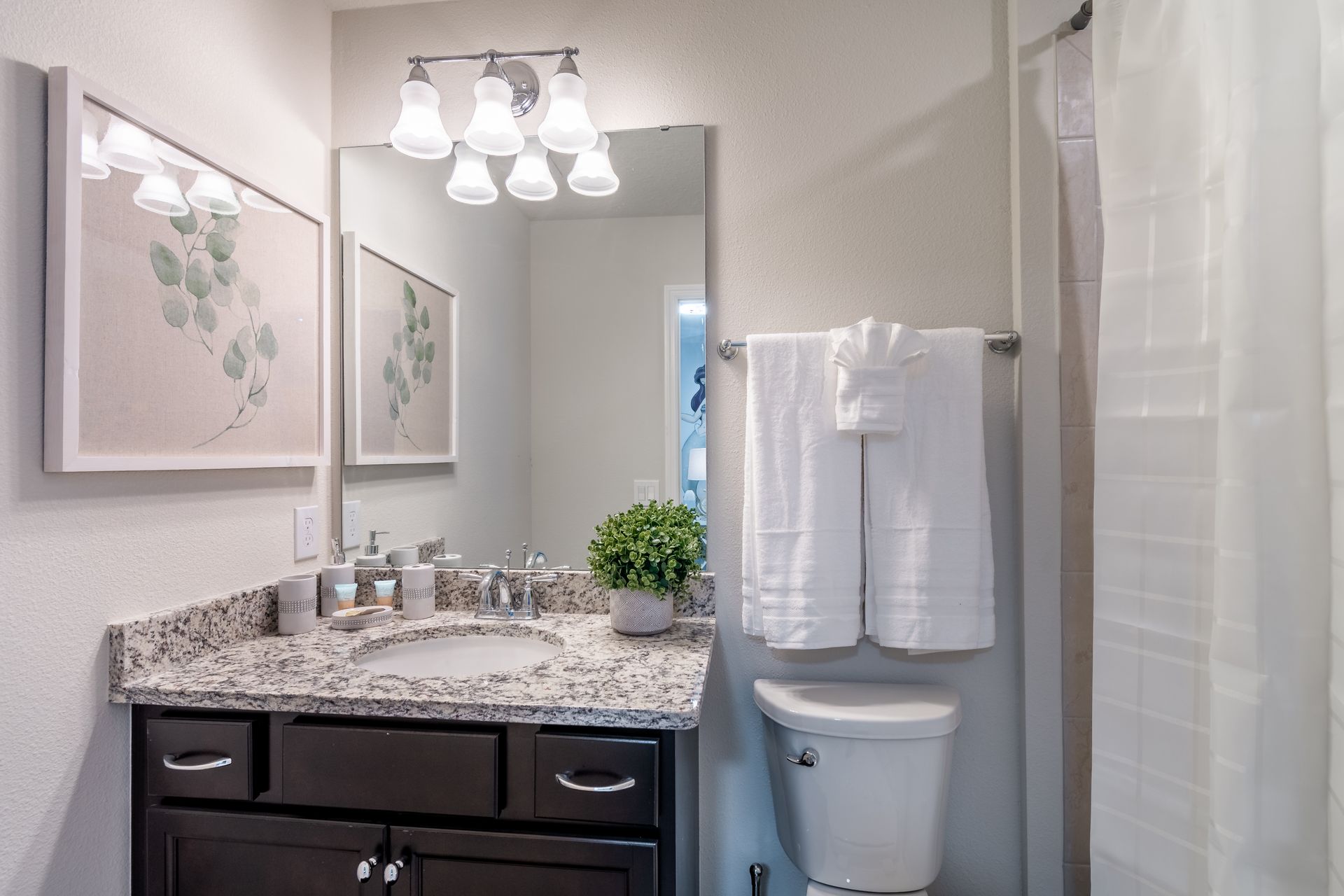 Charming modern bathroom with granite countertops, soft lighting & elegant décor!
