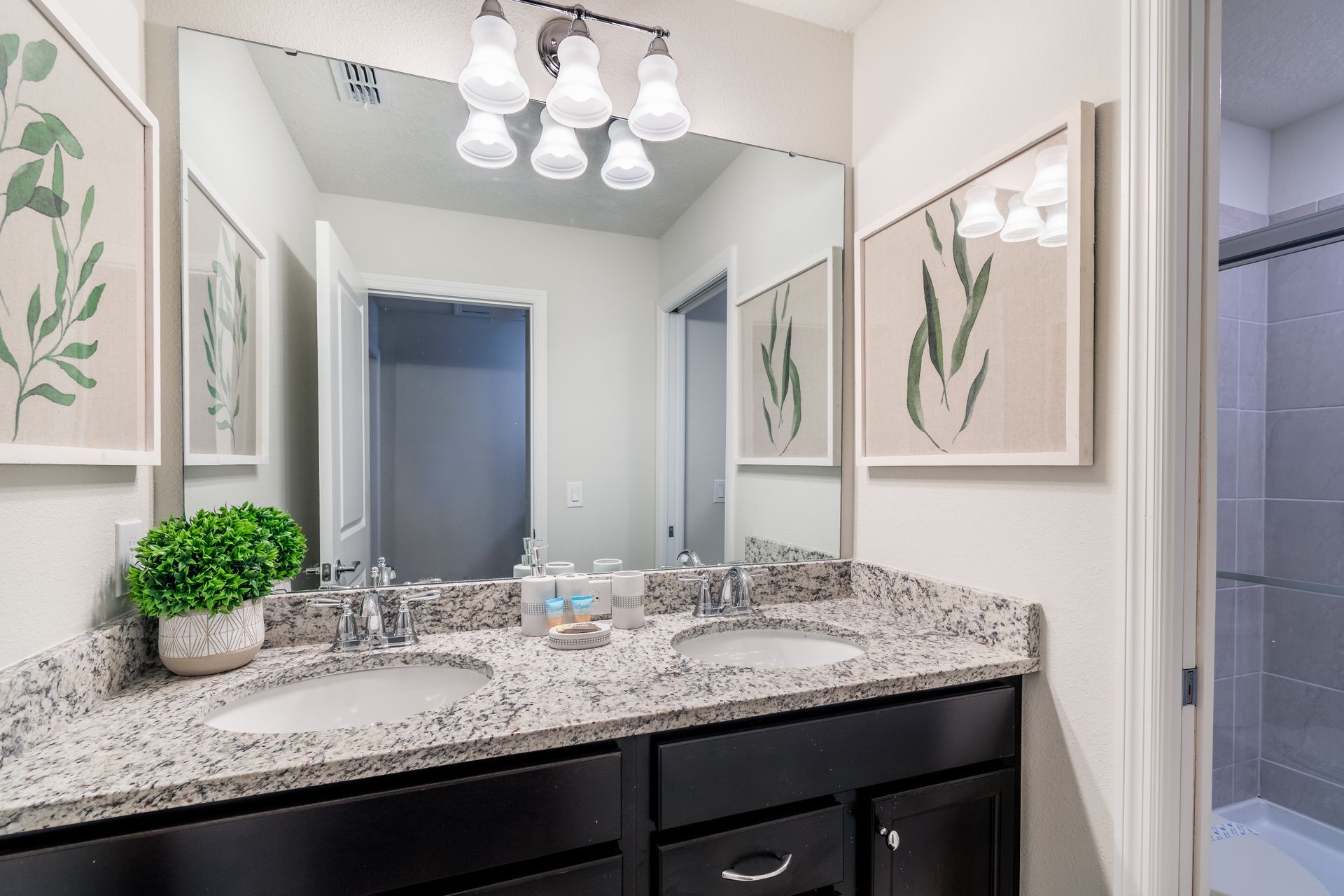 Modern bathroom with dual sinks, granite countertops & elegant nature-inspired décor!