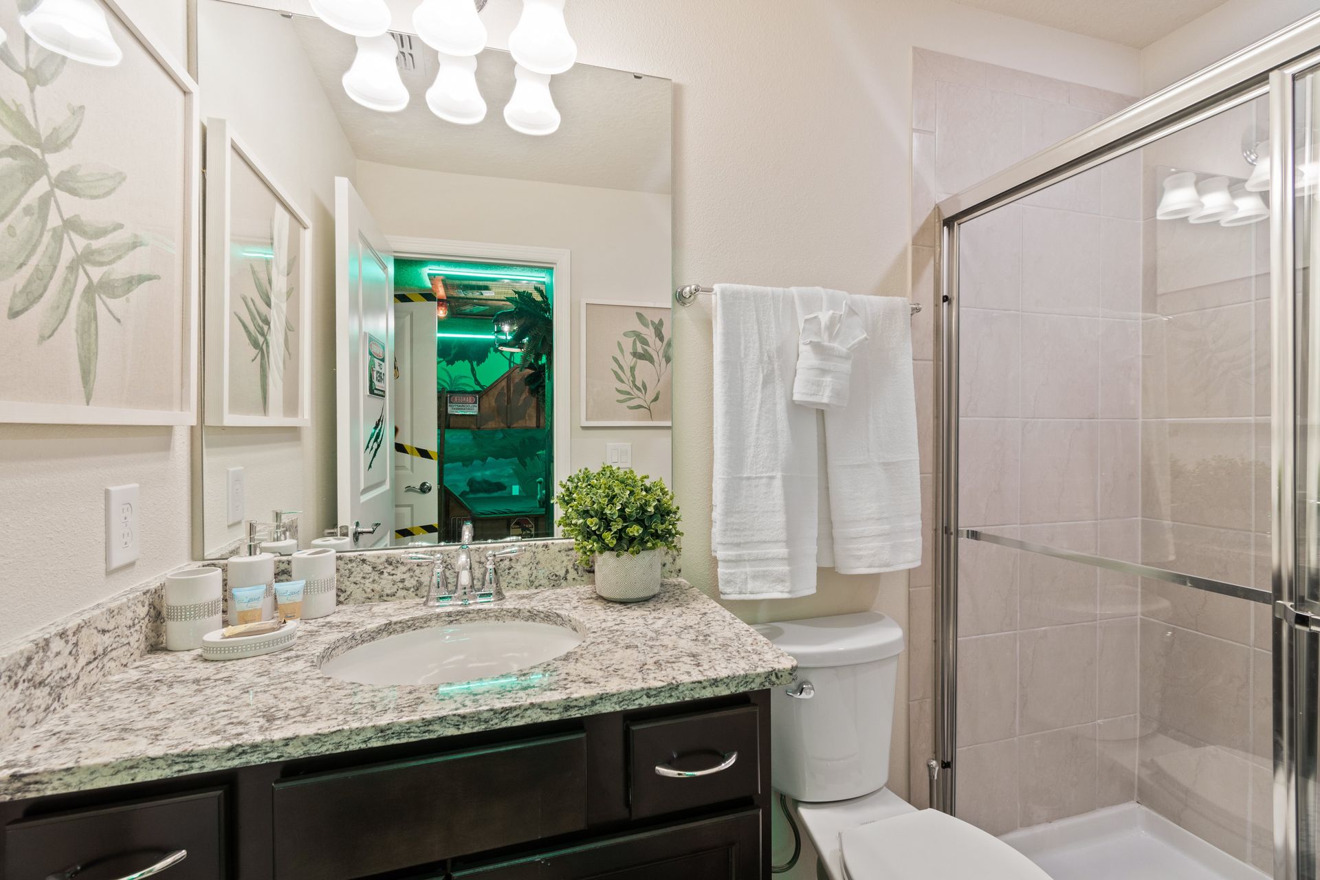 Bright and modern bathroom with granite countertops, a glass shower & fresh décor!
