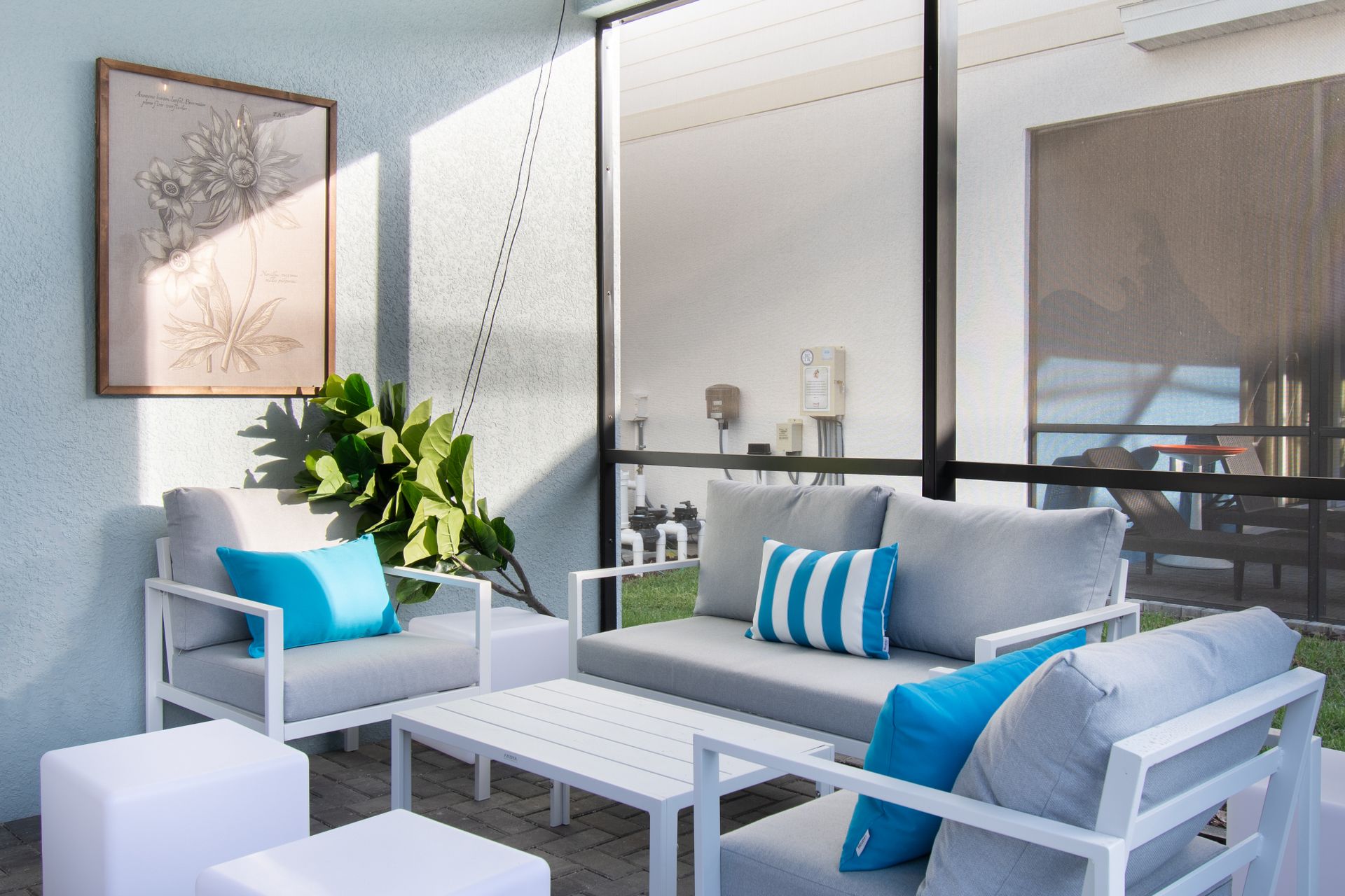 Relax in this stylish screened-in patio with cozy seating, chic décor & breezy vibes!