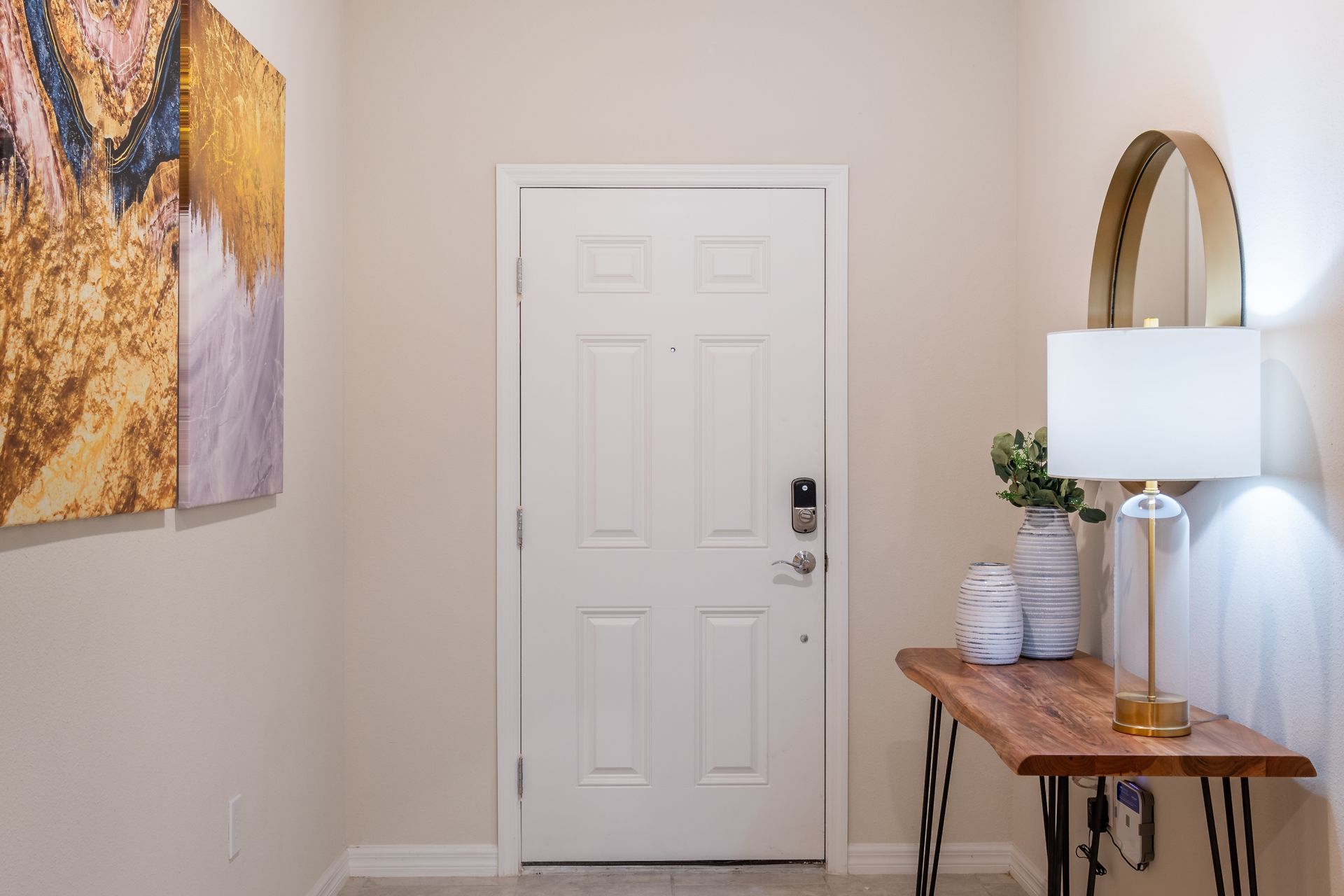 Welcoming entryway with stylish decor, smart lock, and warm lighting.