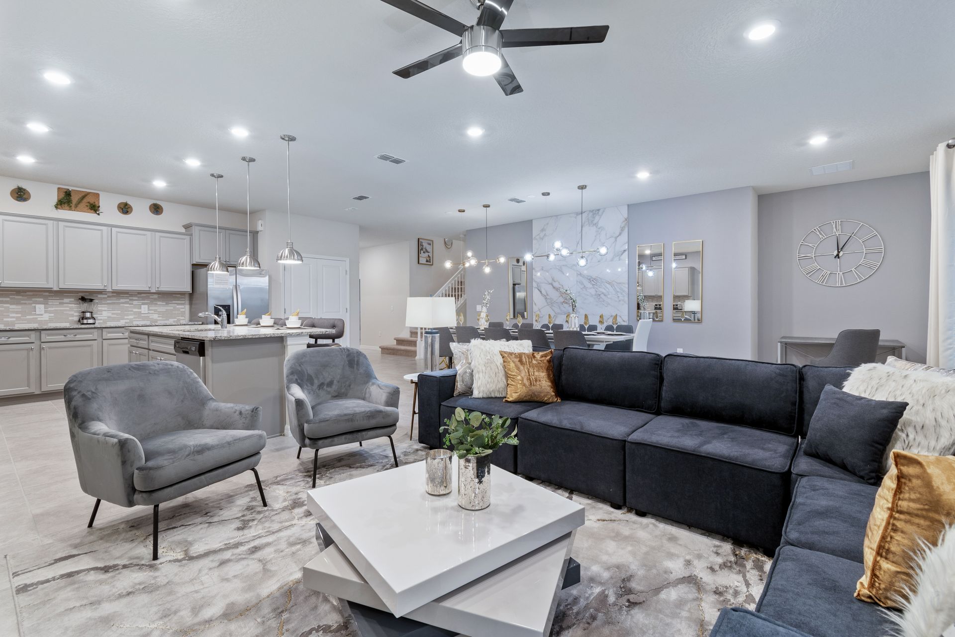 Spacious open-concept living area with modern kitchen, cozy seating, and stylish decor.