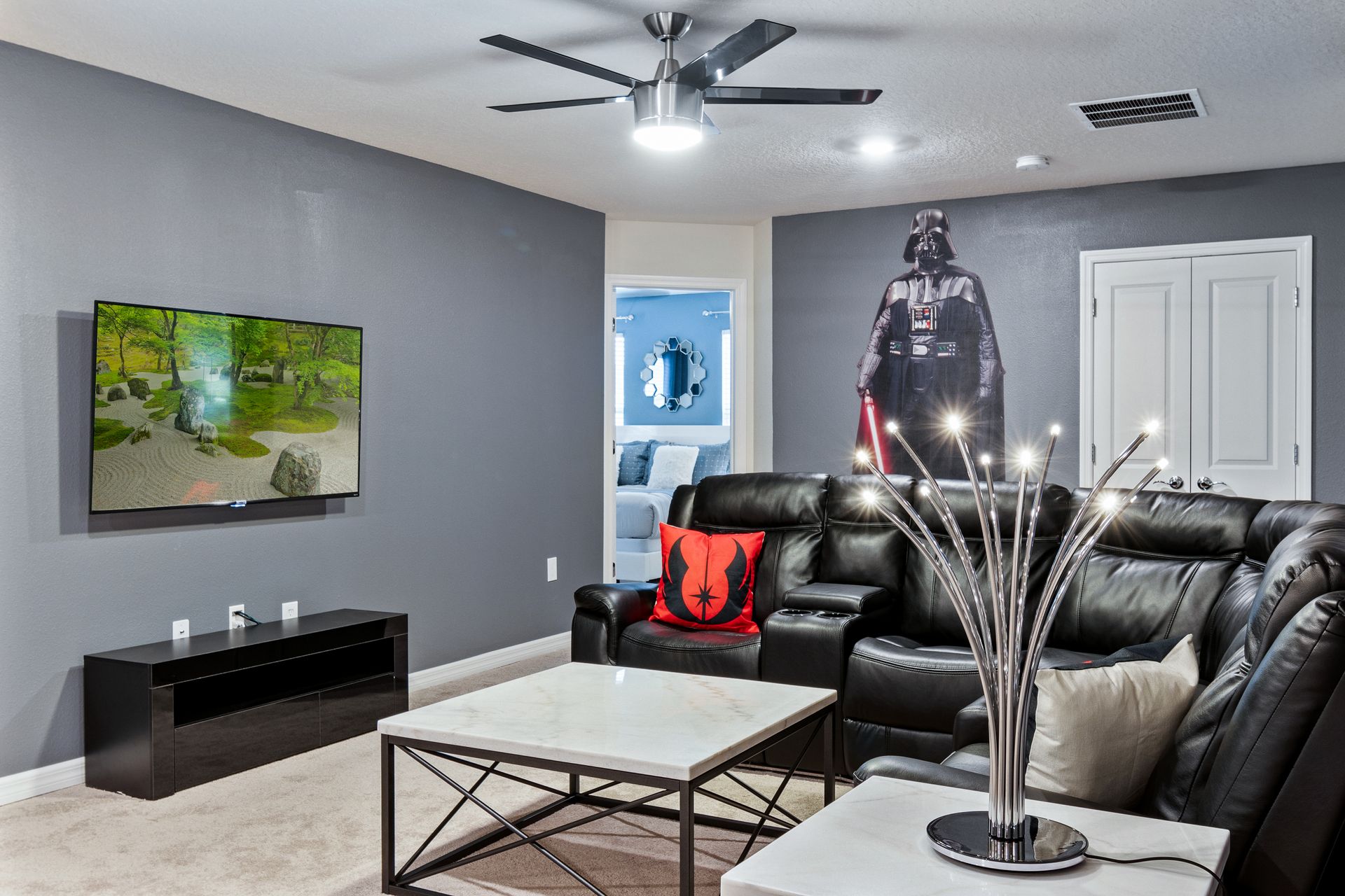 Cozy media room with leather seating, sci-fi decor, and a large TV.