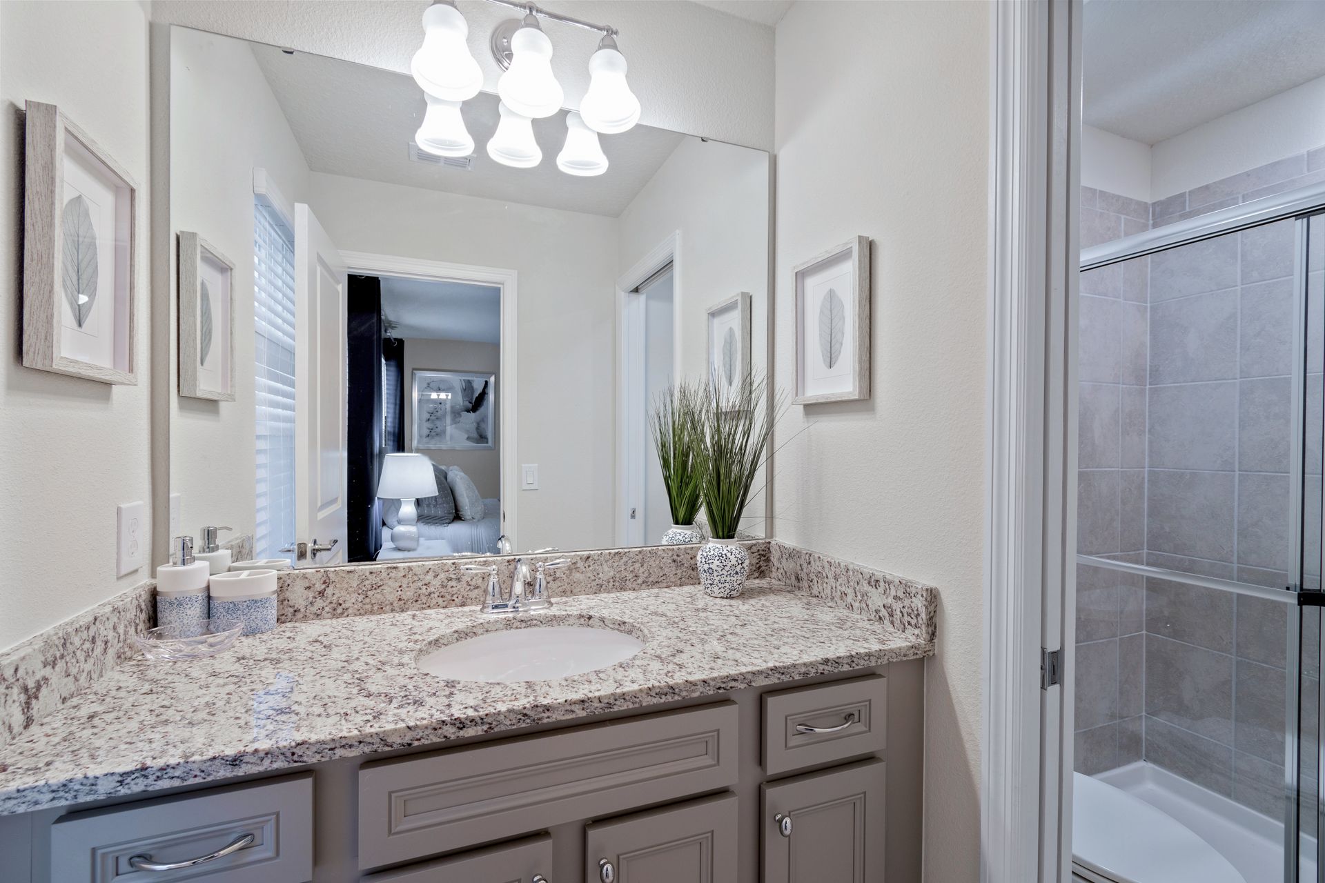 Stylish bathroom with granite counters, glass shower, and modern decor.