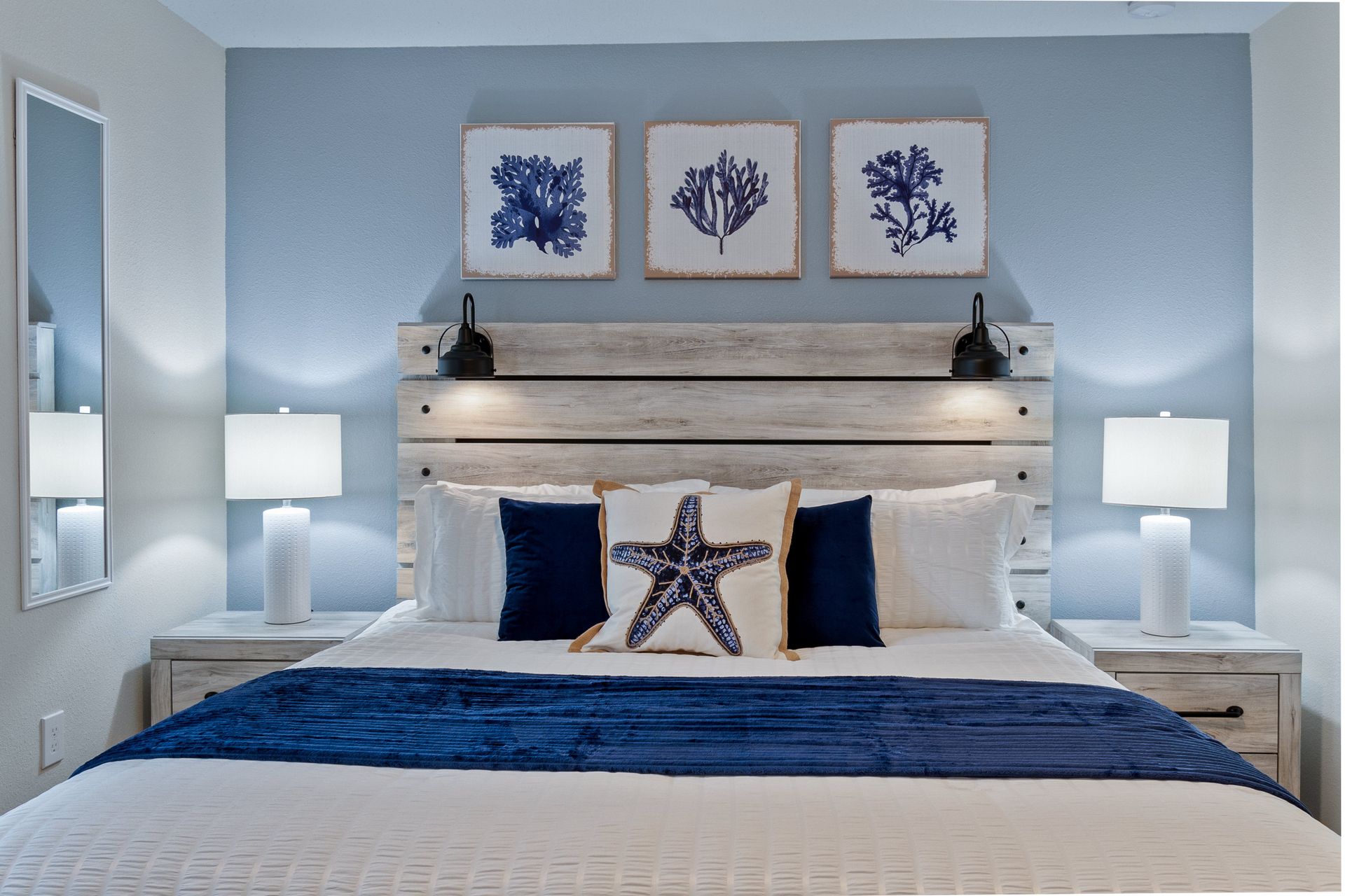 Coastal-themed bedroom with king bed, serene decor, and soft lighting.