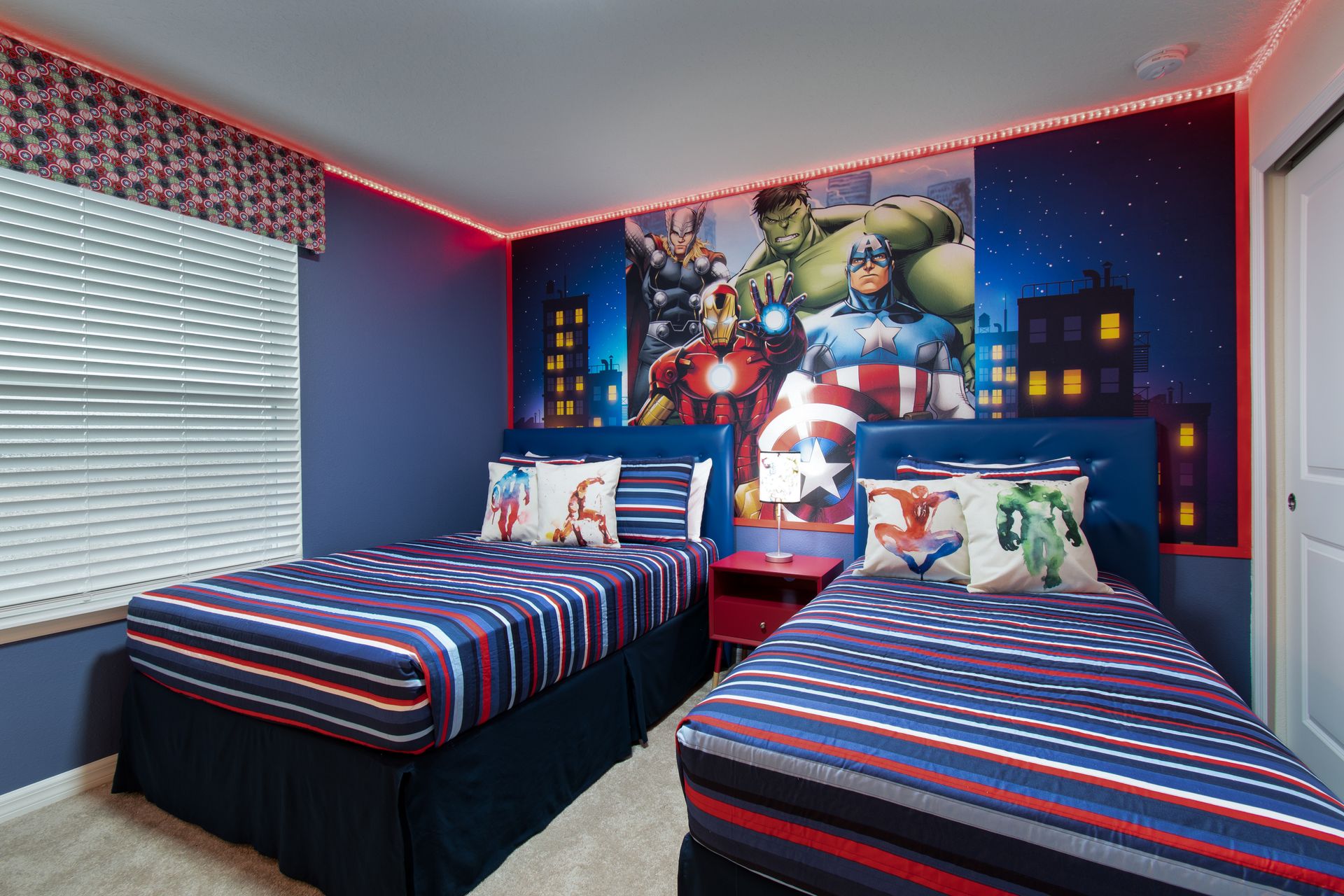 Superhero-themed room with twin beds, vibrant decor, and LED lighting.