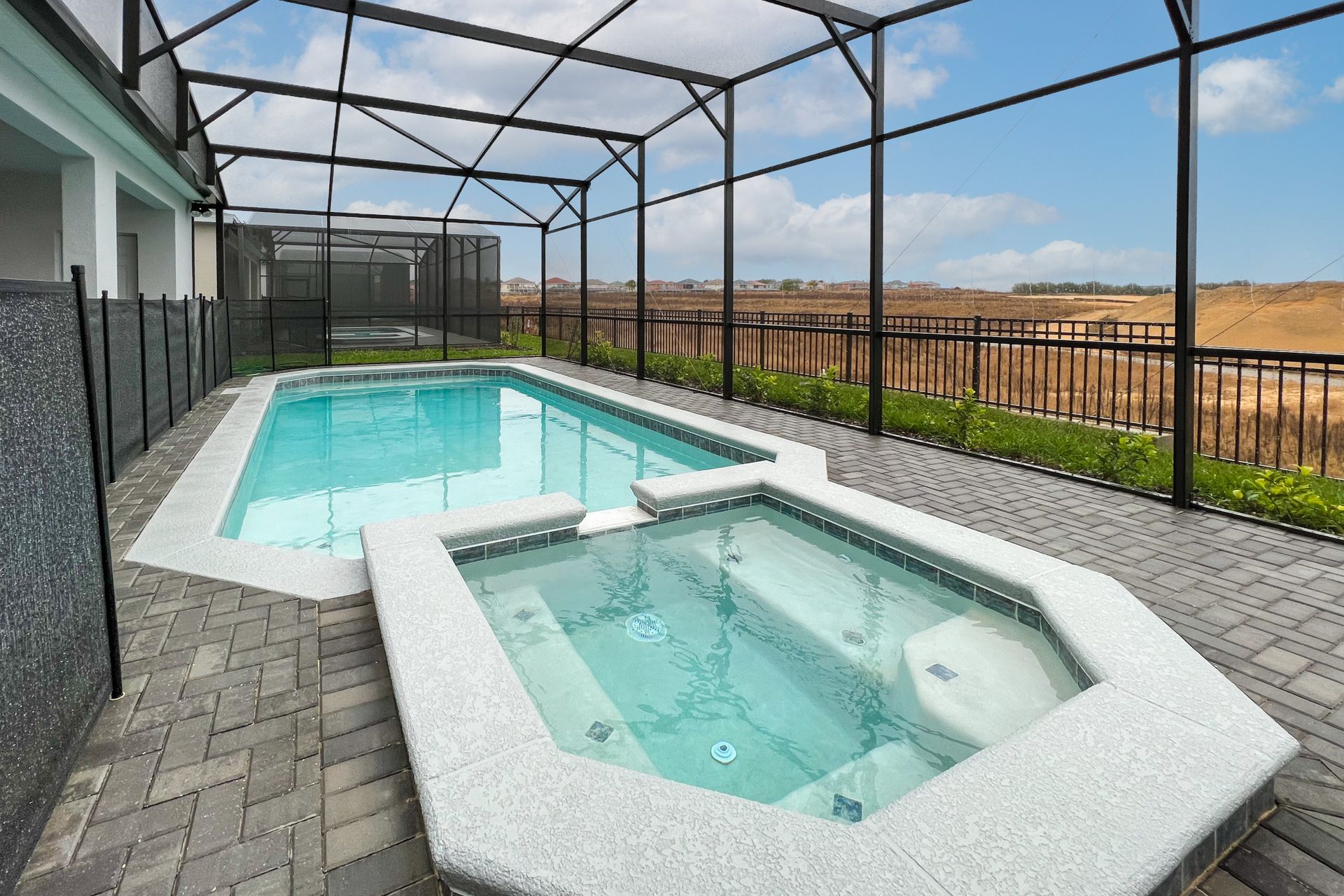 Private pool and spa with screened enclosure, overlooking scenic views.