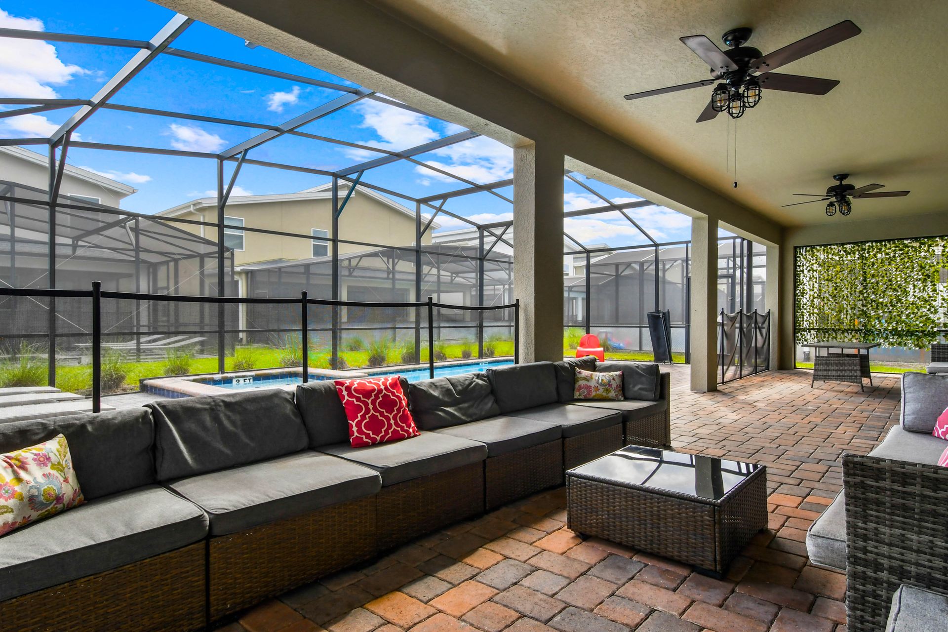 Relax on the spacious patio with cozy seating, fans, and views of the screened pool!