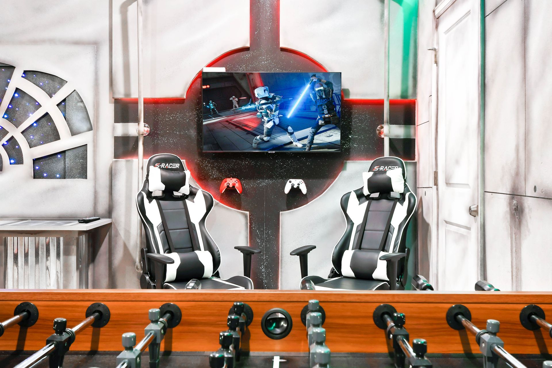 Epic Star Wars-themed game room with gaming chairs, foosball, and immersive decor!