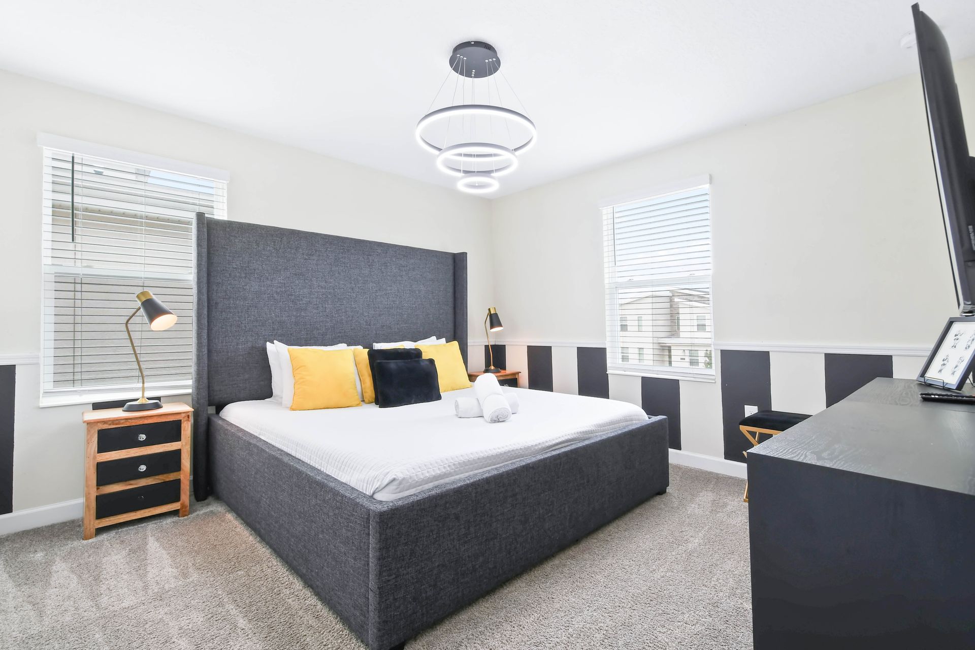 Bright and modern bedroom with a plush king bed, chic decor, and natural light!