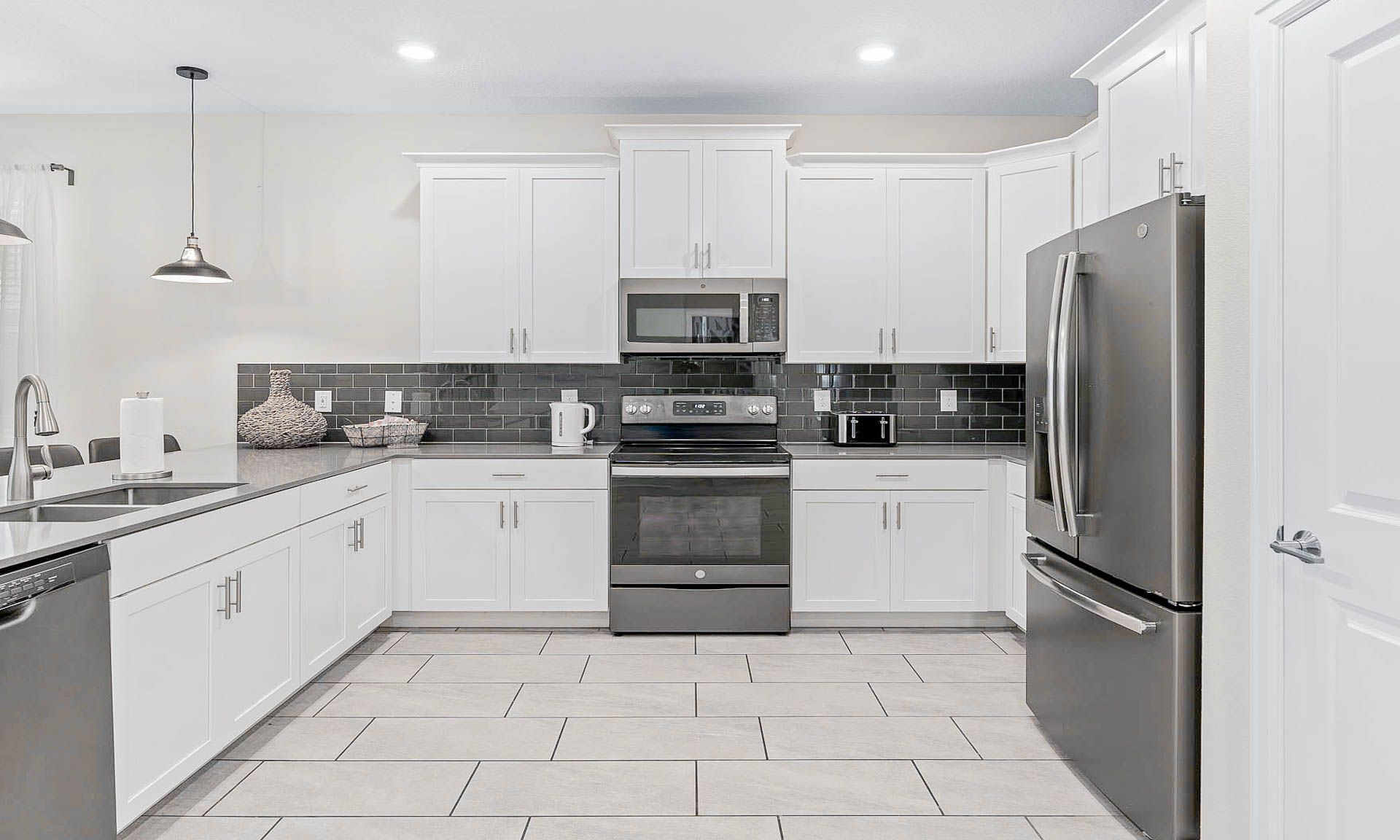 Modern kitchen with stainless steel appliances, sleek backsplash, and ample space!