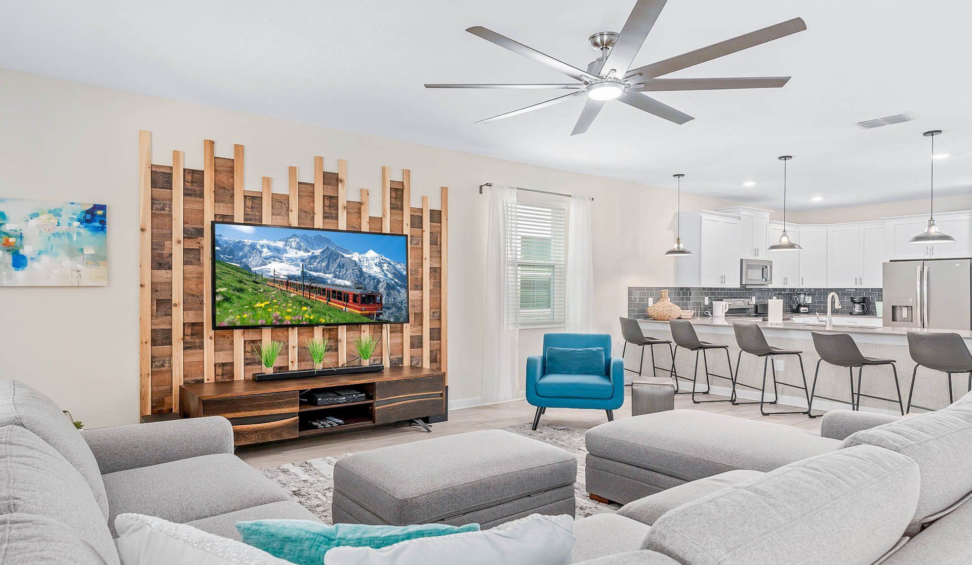Modern open-concept living space with stylish decor, cozy seating, and a big TV!