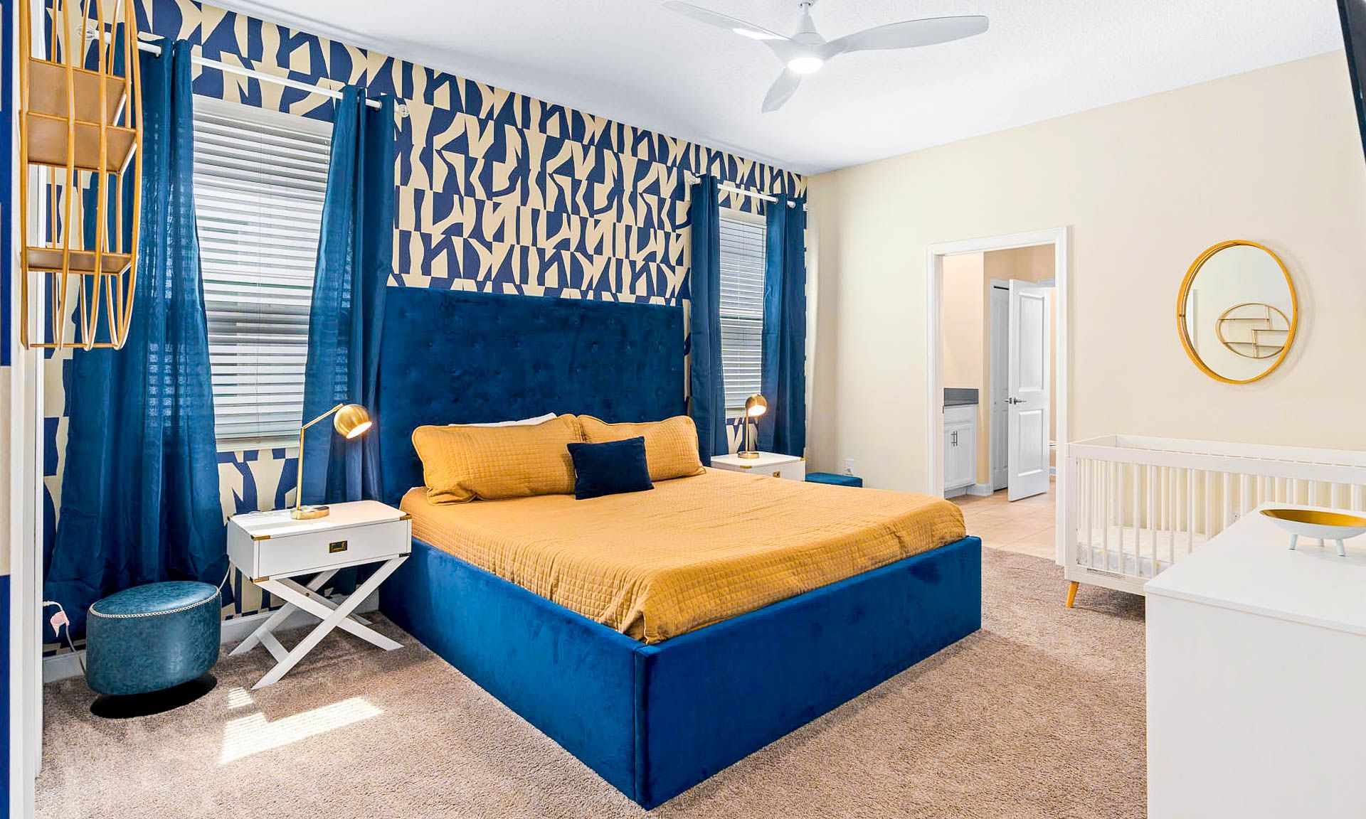 Bold and vibrant bedroom with a plush bed, geometric accents, and a cozy crib!