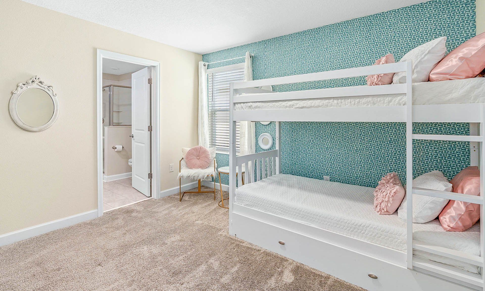 Charming bunk bedroom with playful decor, cozy seating, and a private bathroom!