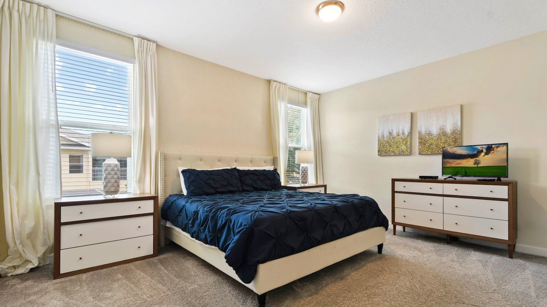 Elegant bedroom with a plush bed, modern decor, and plenty of natural light